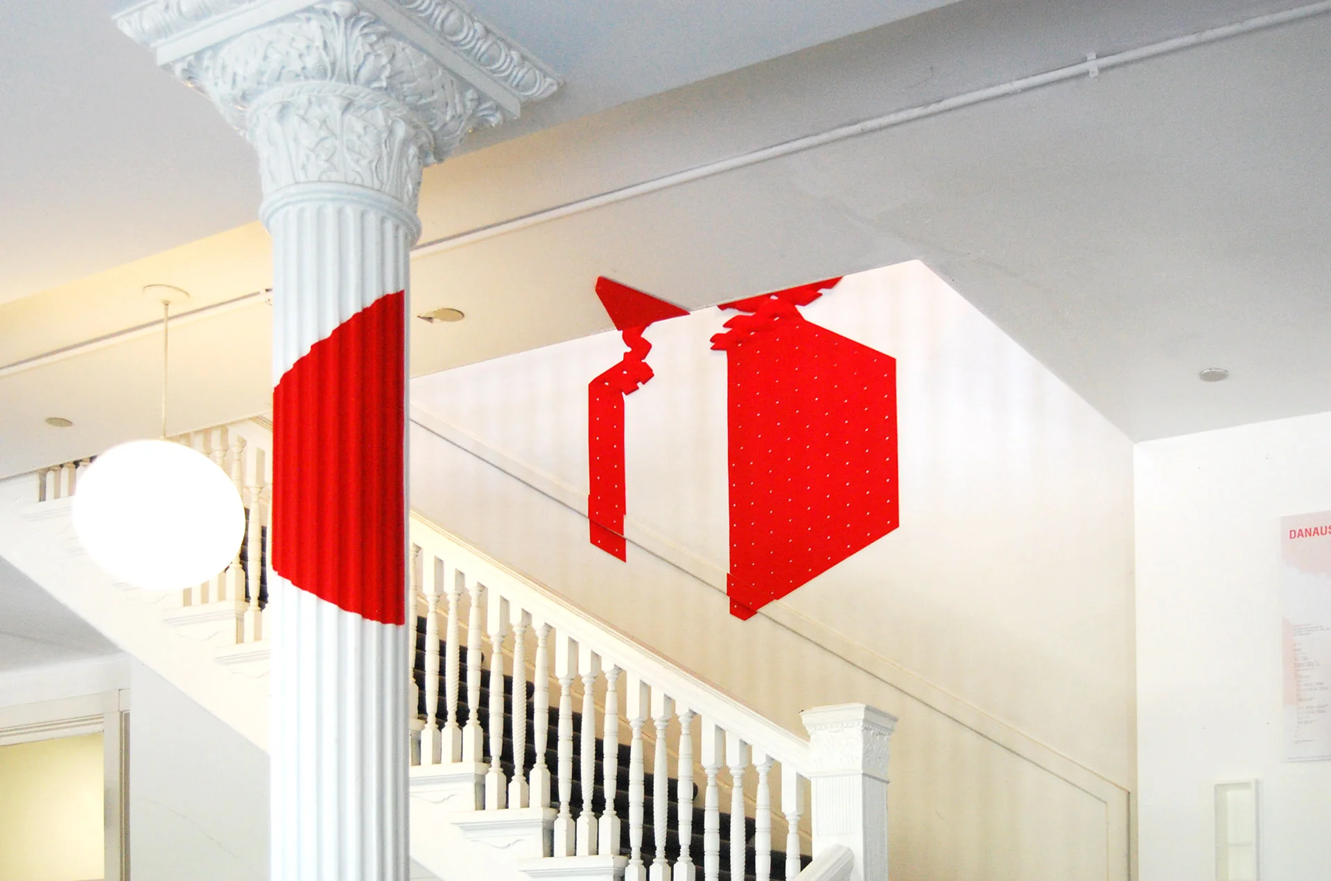 Inspired by the work of French artist George Rousse, the student designers created a red cube made out of thin fragmented pieces in the shape of a hexagon. After entering Richardson Memorial Hall, one is confronted with the complete perspective of the cube right at the door. As one steps in and walks up the stairs in the lobby, the perfect cube reveals itself in the fragmented composition and begins a morphological process towards the floor above. Starting from small 4-sided polygons on the cube, the voids gradually morph into 5 and 6-sided shapes, simultaneously growing in size while diminishing in spacing. The designers digitally scripted this reciprocal relationship between size and spacing to formulate another level of transition in the visual, namely from the subtractive to the additive, and further articulated it to allow Danaus a function that emerges out of its own form. 
