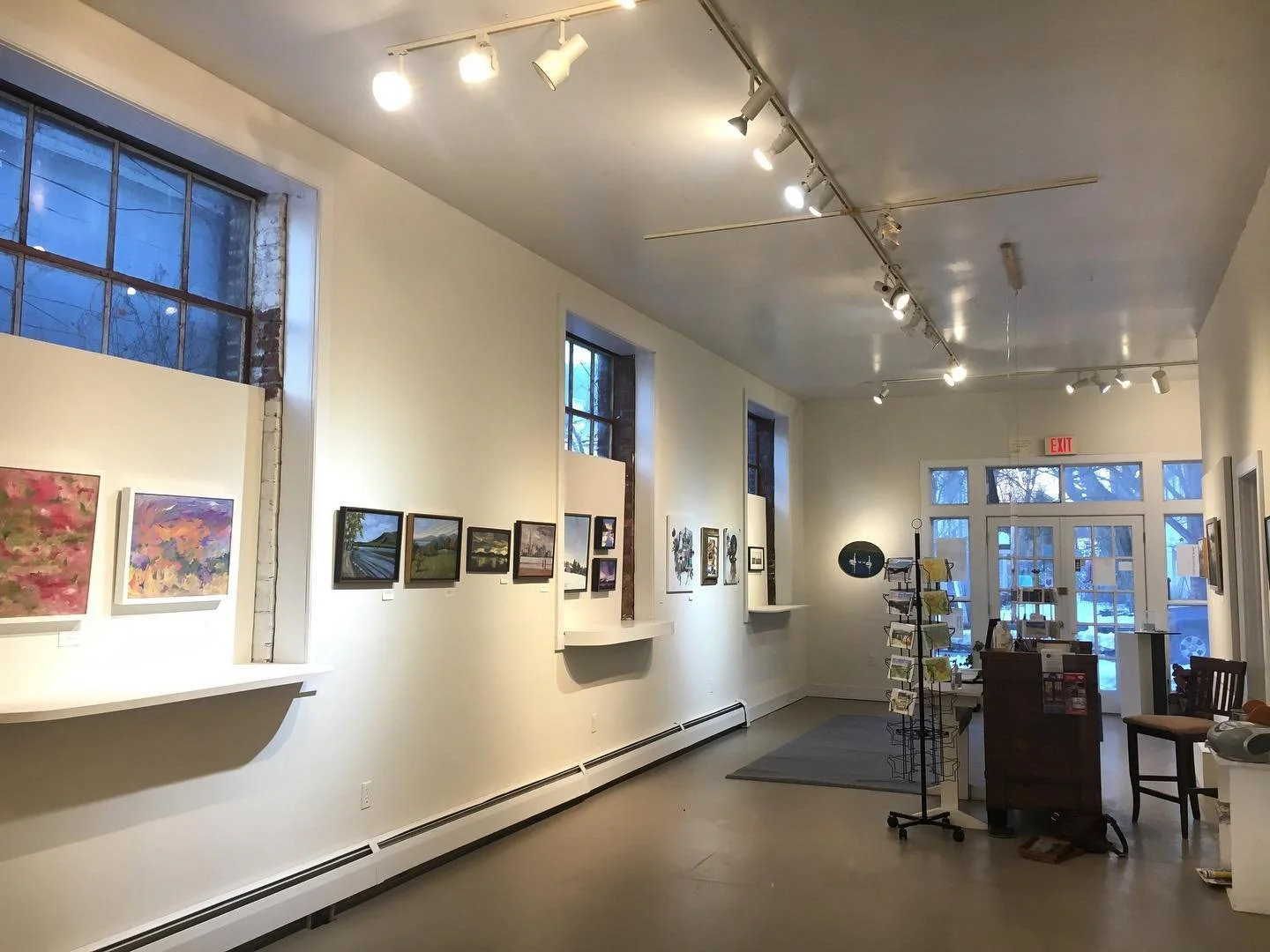 Interior of art gallery with paintings on the wall.