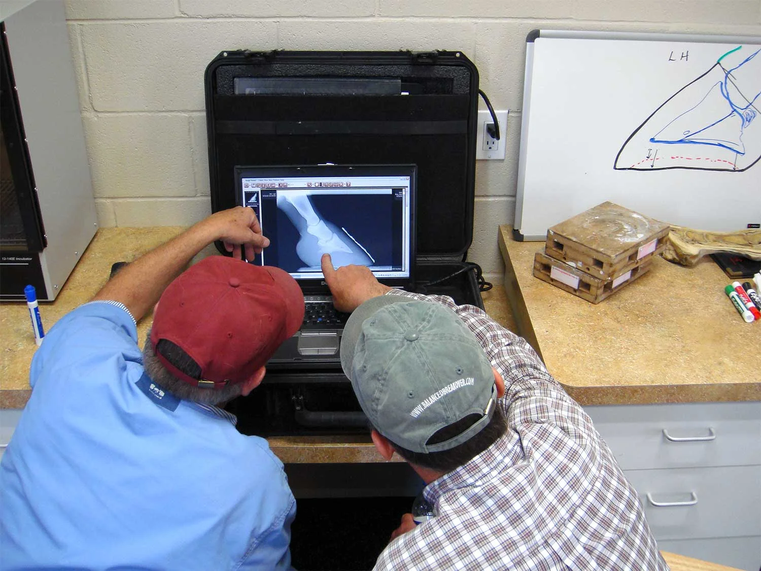 Dr. Jensen and farrier Pete Healey discussing Metron report