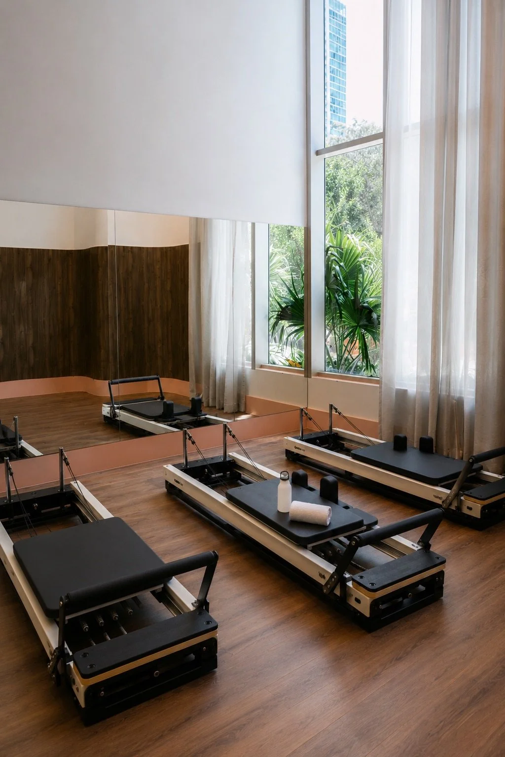 Private Nofar Method Pilates studio at 2200 Brickell, with Reformers and Cadillac equipment beside floor-to-ceiling windows. Image courtesy of 2200 Brickell / Levy Public Relations.