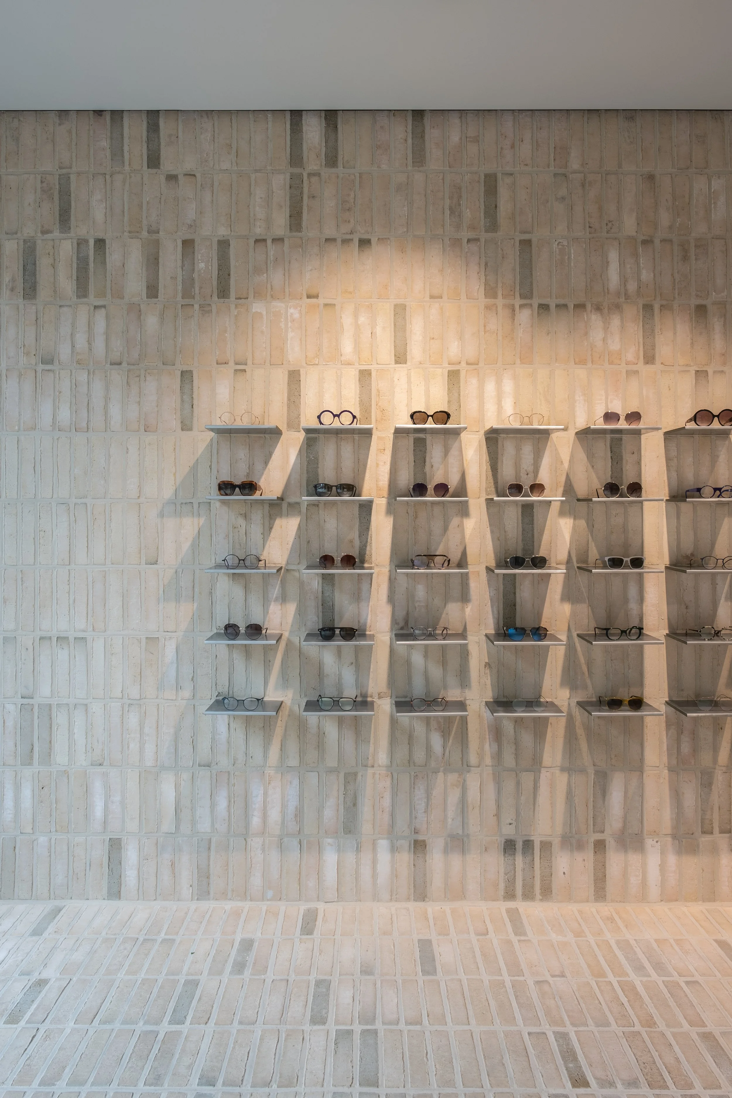  Designed around the act of seeing and being seen, the interior transforms a long and narrow retail space into an open, light and dynamic environment. Mirrors become an integral part of the architecture — enhancing both the experience of choosing eye