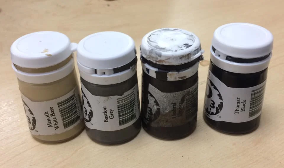 Here's a colour comparison just in case you don't have access to P3. Bastion Grey is a warm brown/grey, Menoth White is a dark bone and Umbral Umber is a dark blue/brown.