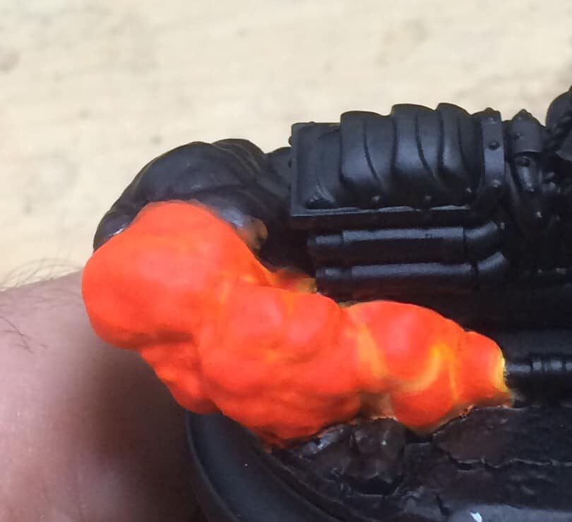 A 50/50 mix of Fluro Orange and Khador Red Base was applied to bring out the smoke clouds. Once again our previous colour was left in the recesses.