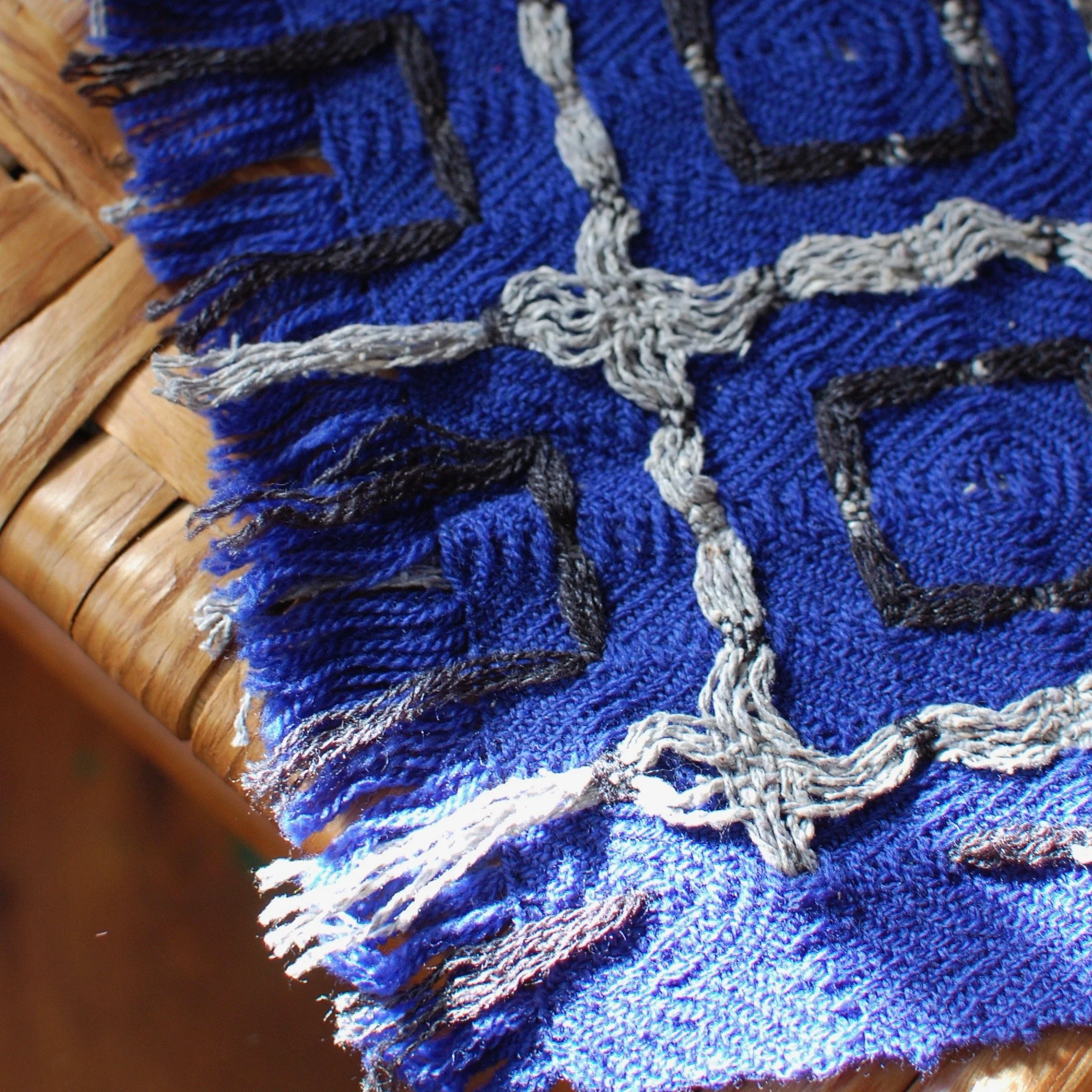 detail of a hemstitched fringe cut short on a merino and silk handwoven shawl