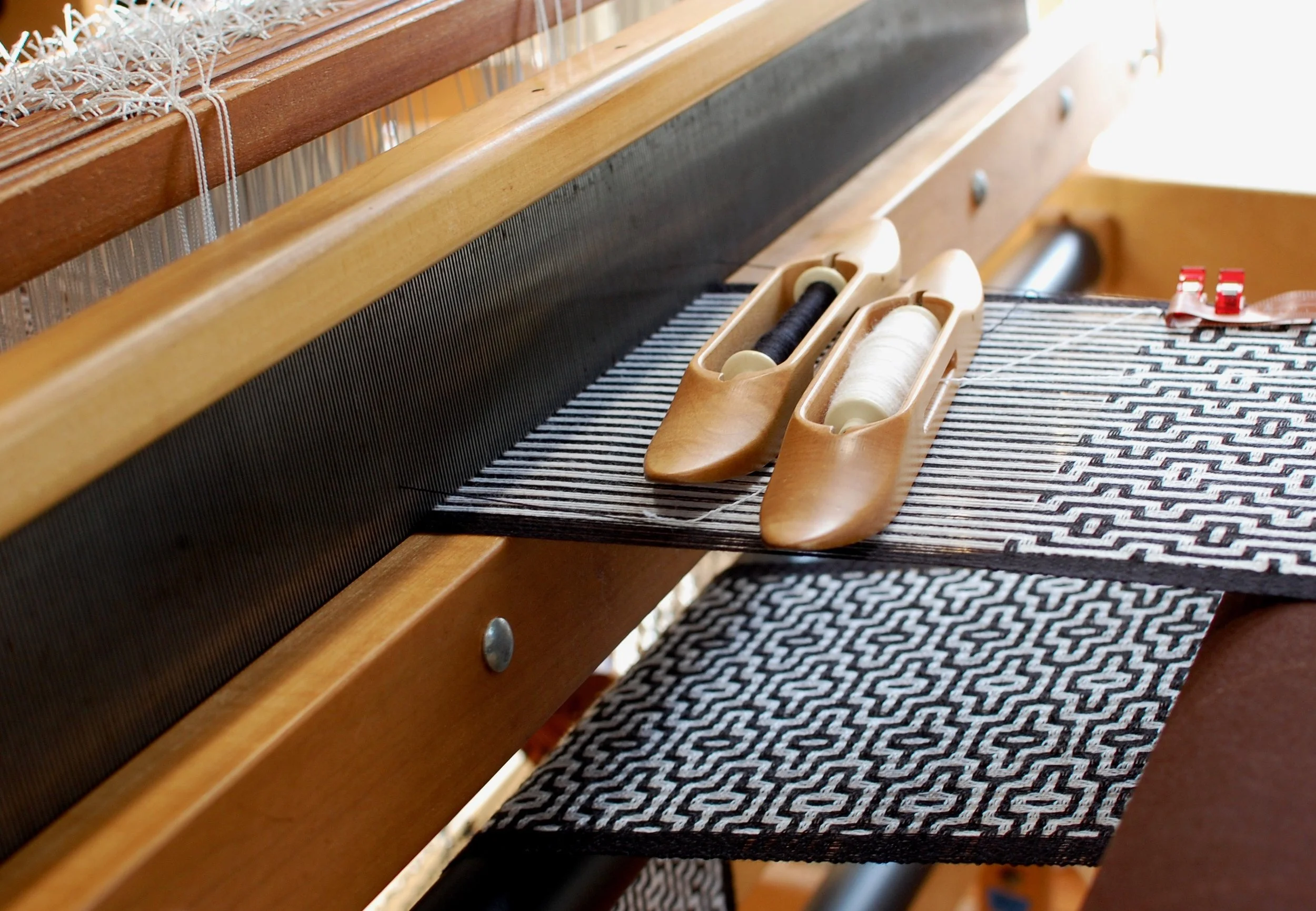 deflected doubleweave cloth being woven on a loom.