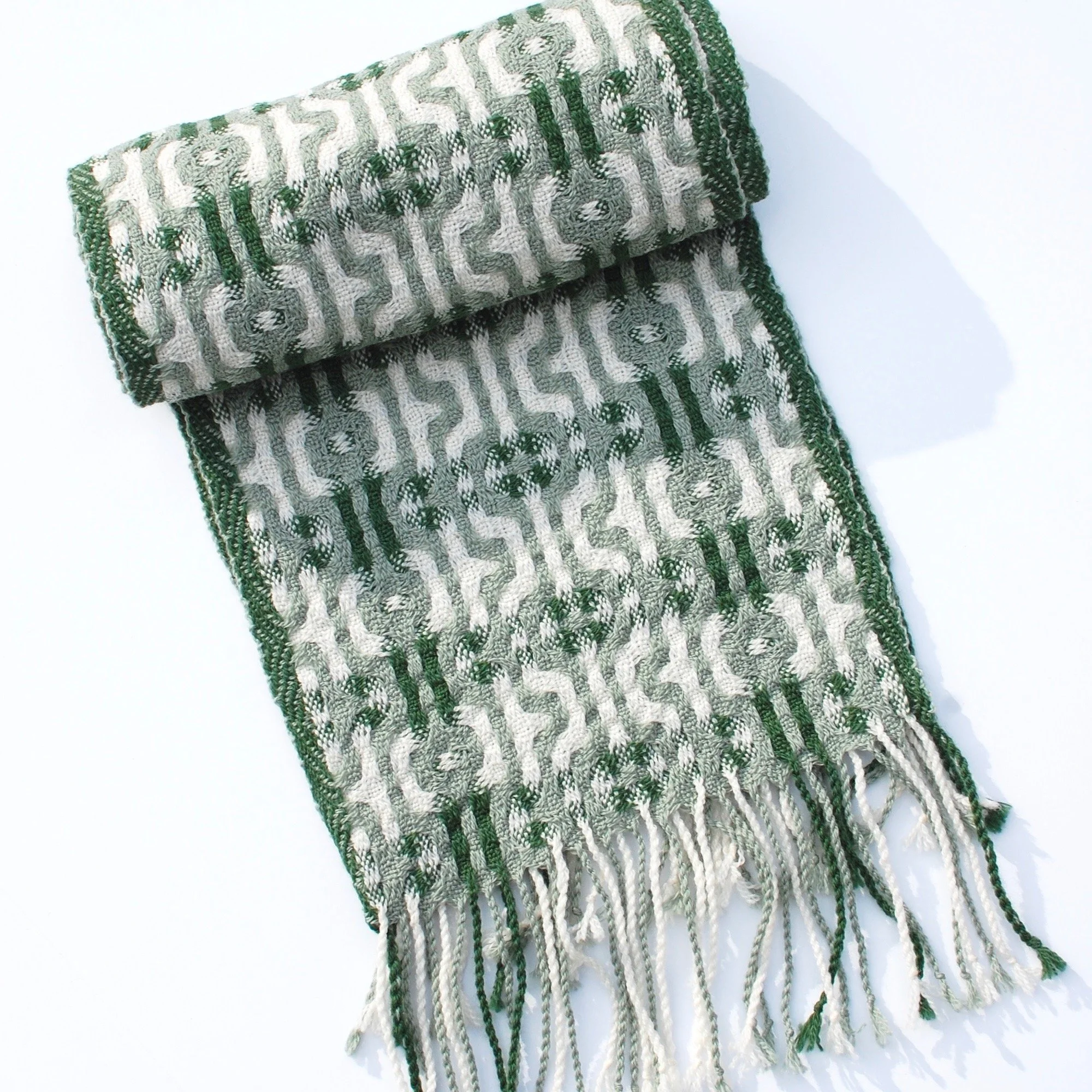 Green handwoven scarf rolled up