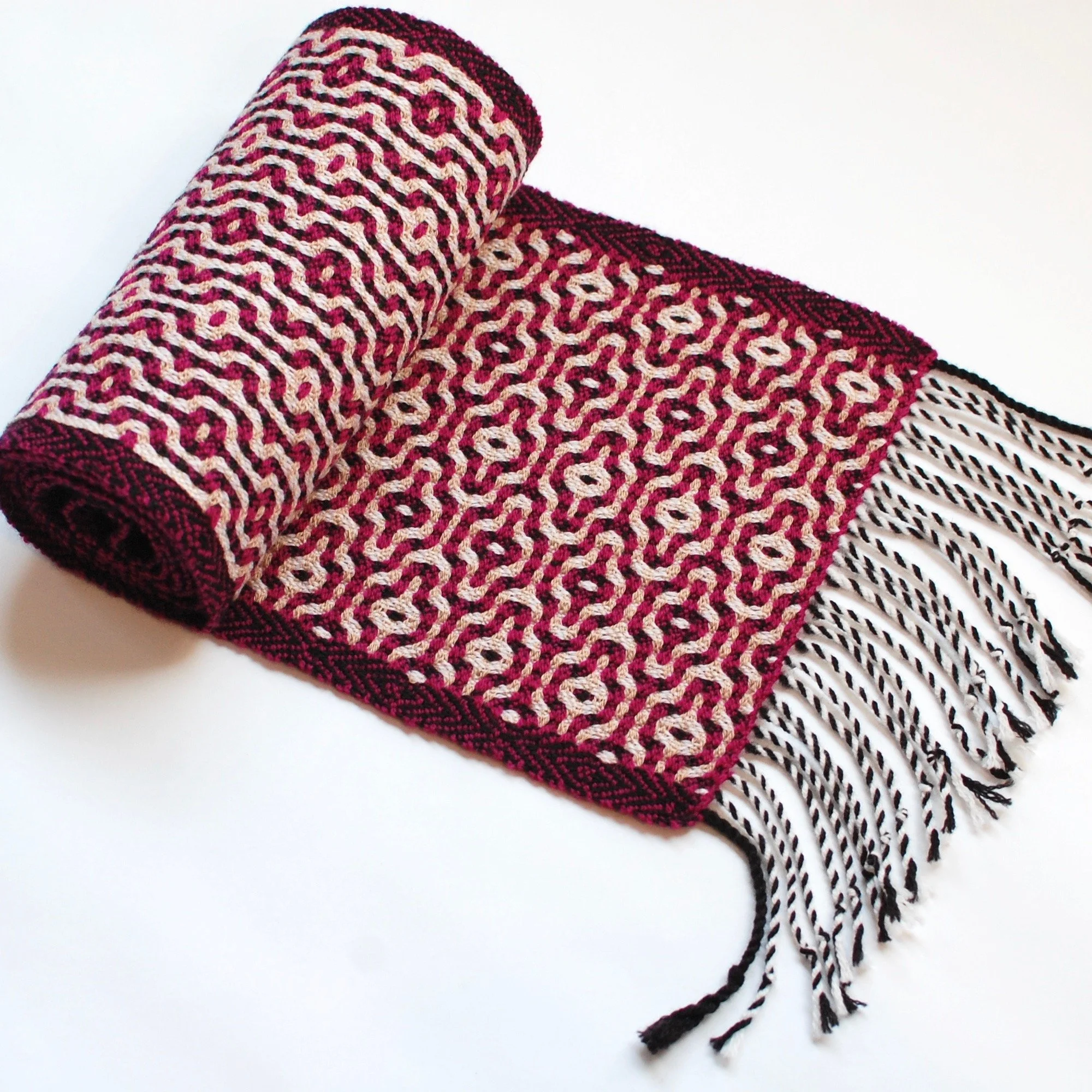 Handwoven scarf rolled up with twisted fringe