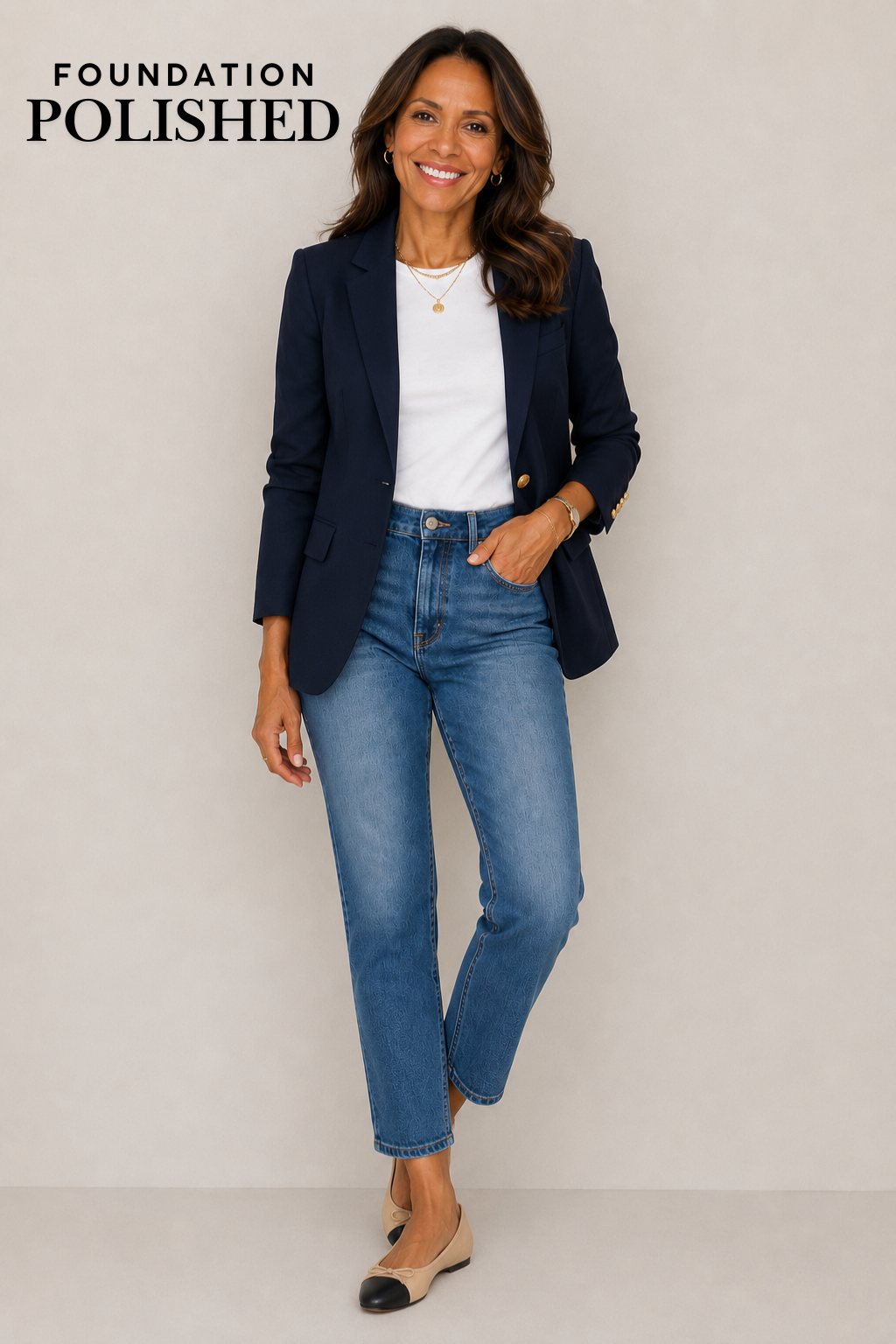 Woman in her 50s wearing a white tee, blue jeans, navy blazer and cap toe ballet flats.
