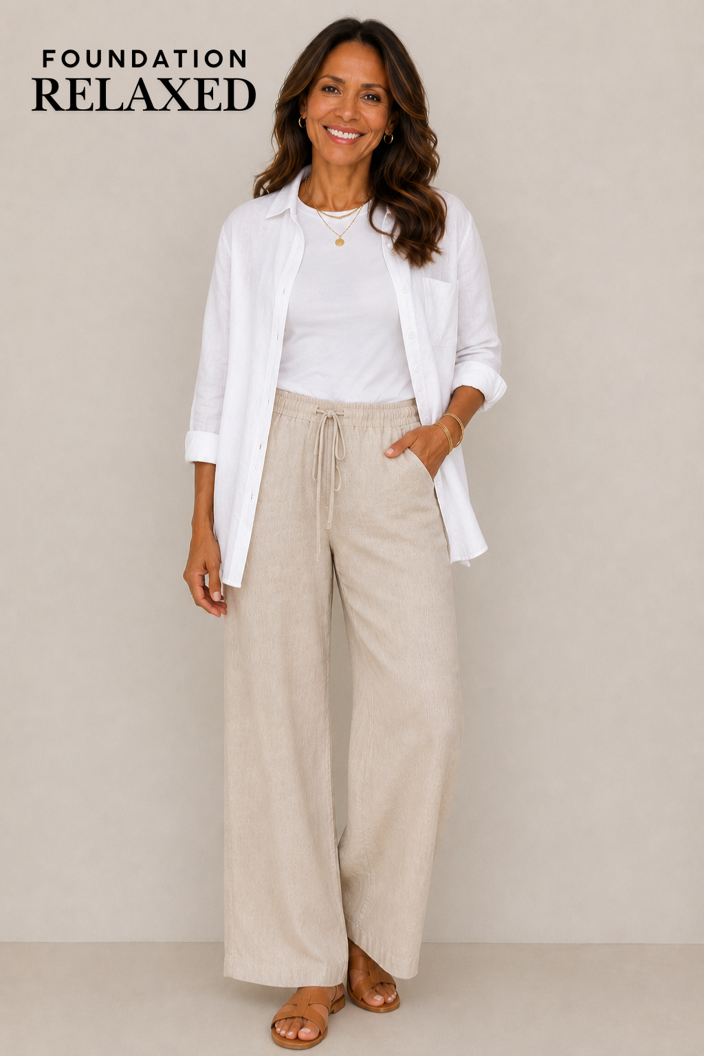 Woman in her 50s wearing a white tee, wide leg linen pants and sandals.