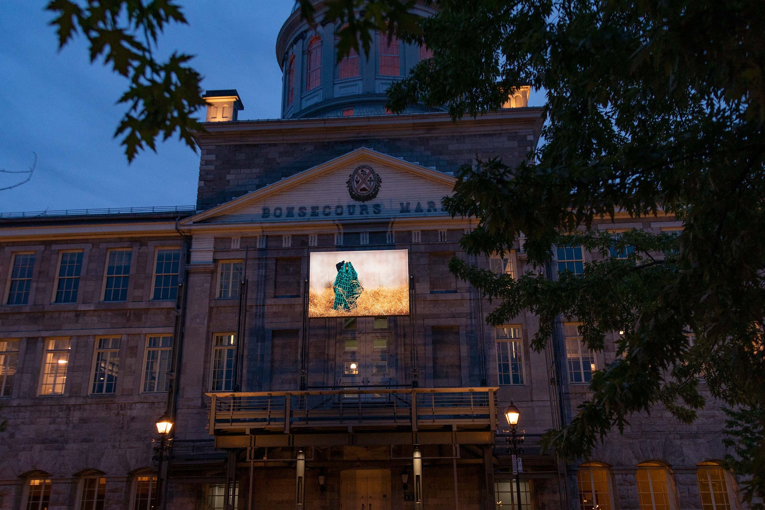  © Lara Kramer,  In Blankets, Herds and Ghosts  (2021). Vue d’installation sur la façade du Marché Bonsecours, Dazibao, 2021. Photo : Manoushka Larouche. 