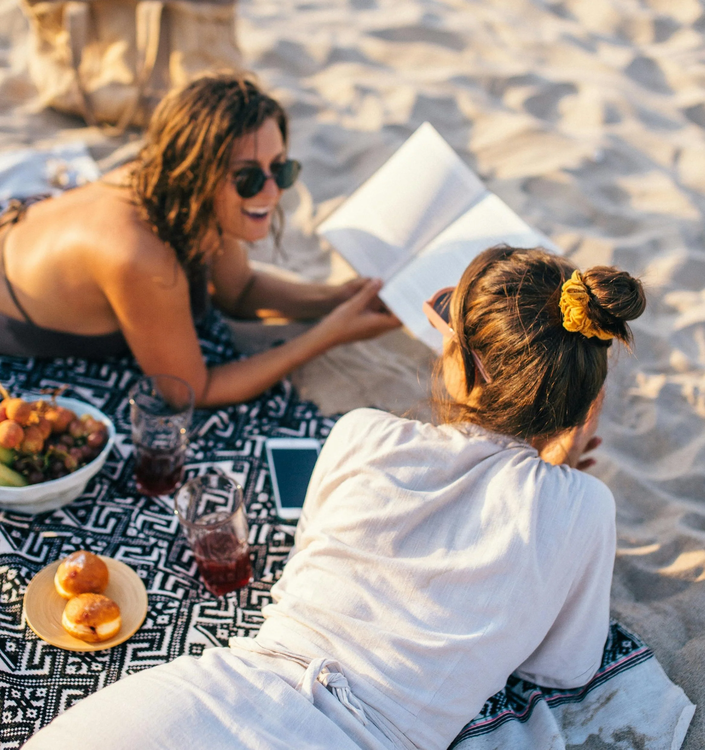 dos mujeres amigas leyendo en la playa book club.jpg