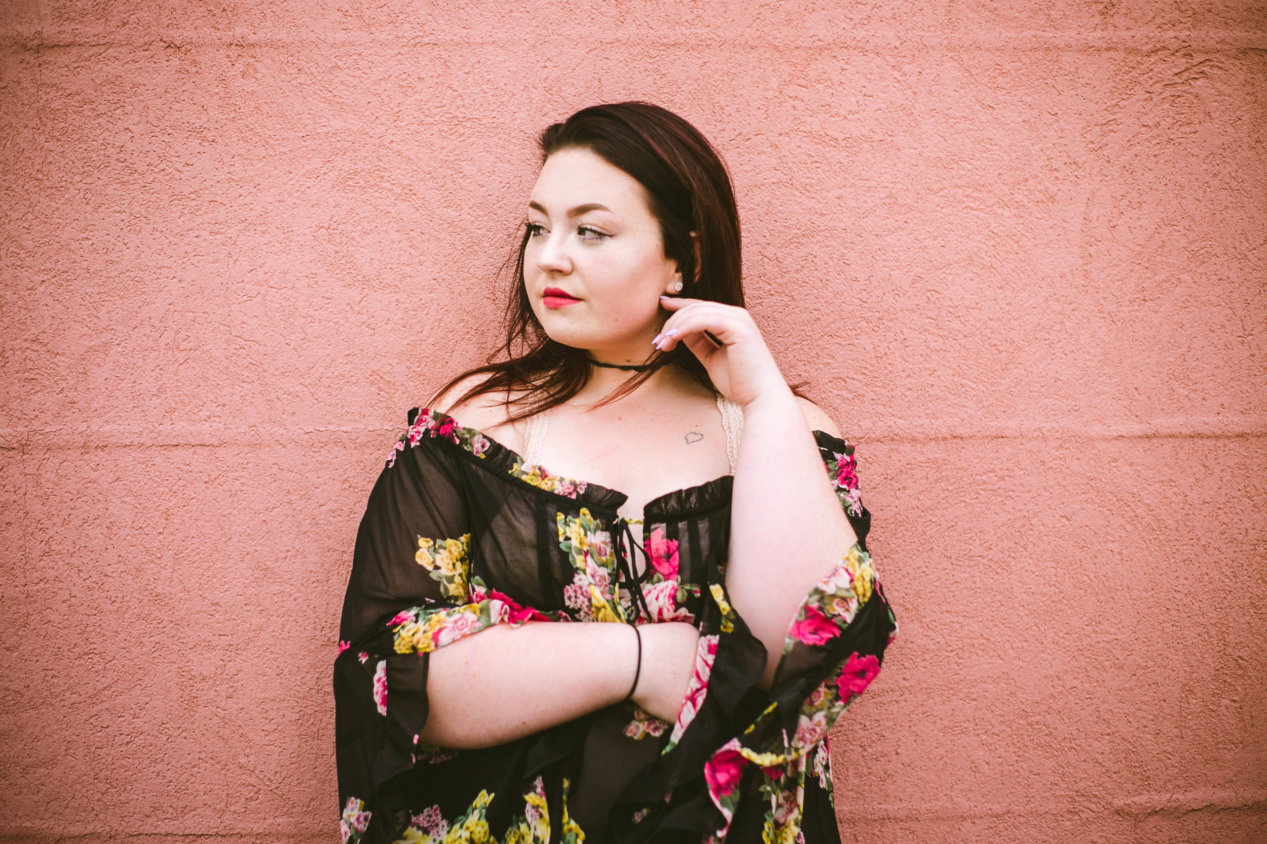 Beautiful high school senior on pink monochromatic wall in Hudson WI