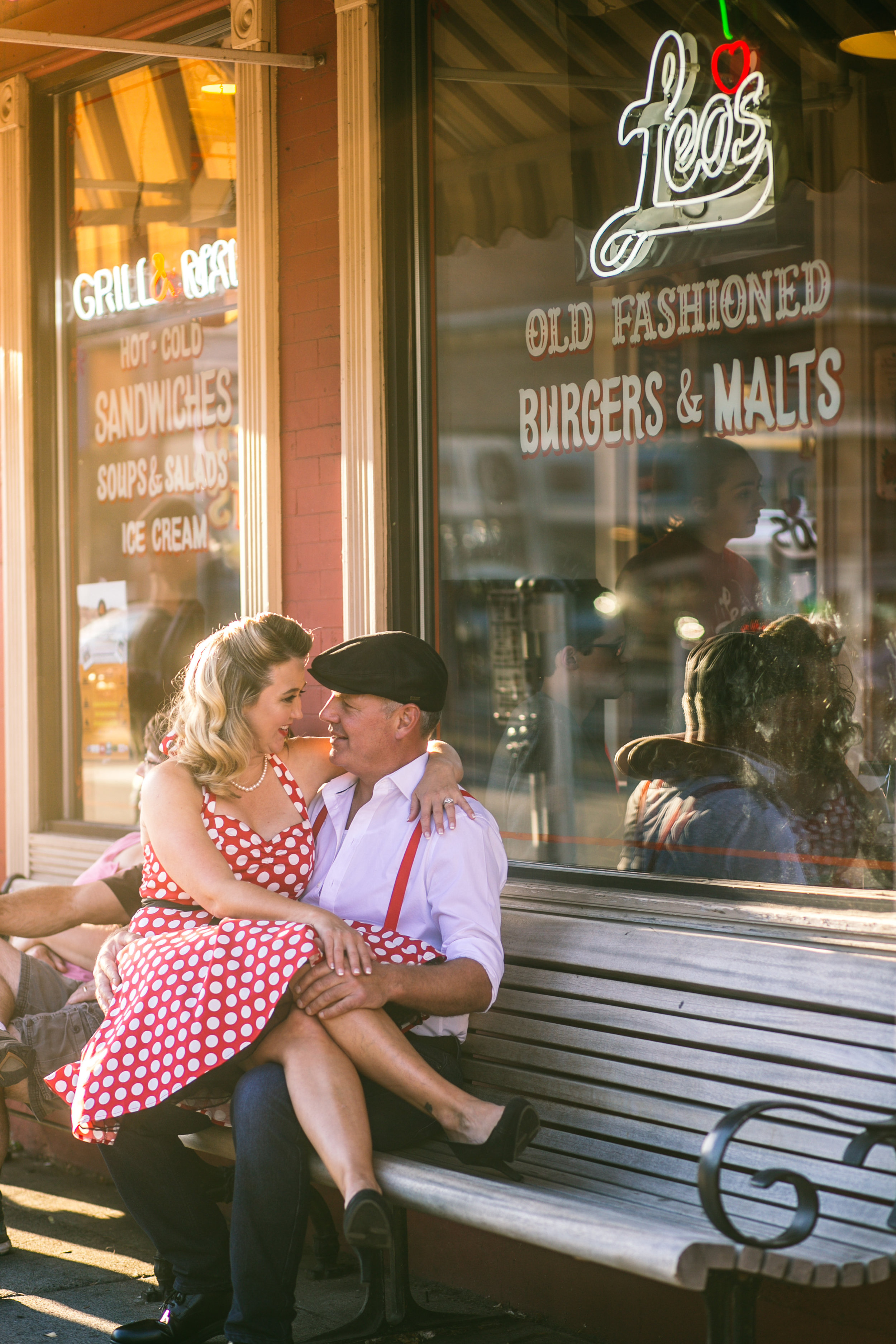  A 1940's vintage couple kissing in front of Leo's Ice Cream in Stillwater MN during their engagement session 