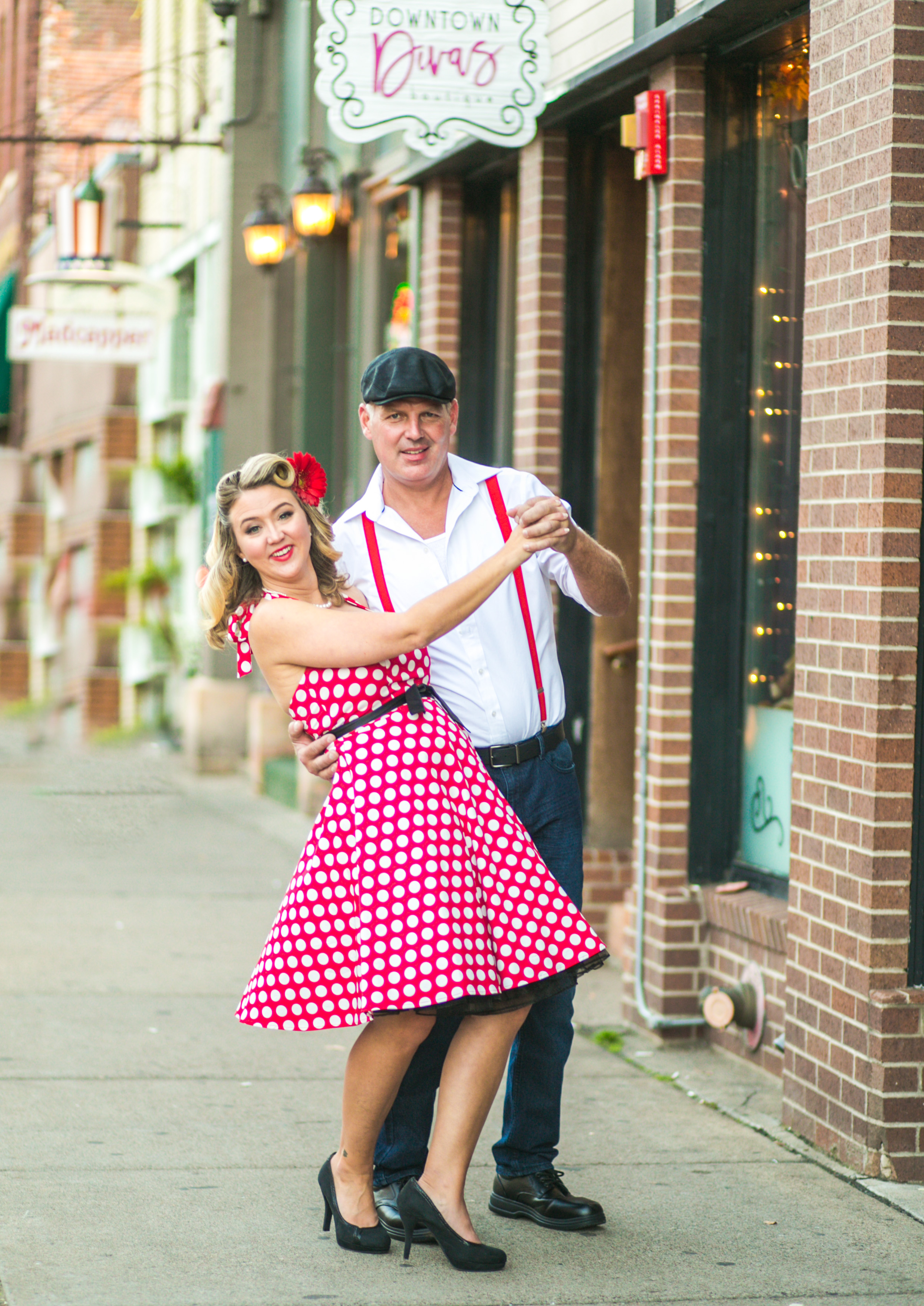 Engaged couple dances on the sidewalk in Stillwater