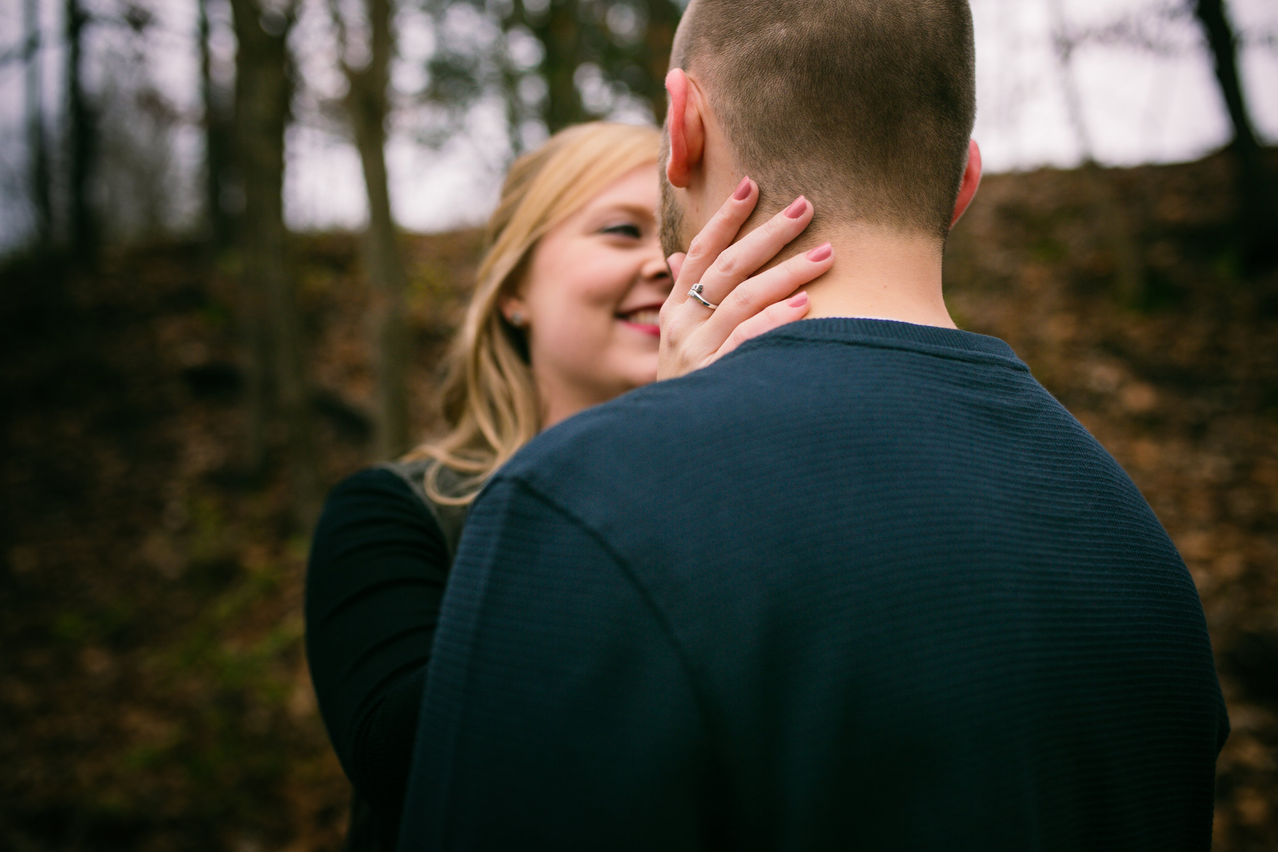 woman smiling at fiancé with hand on neck