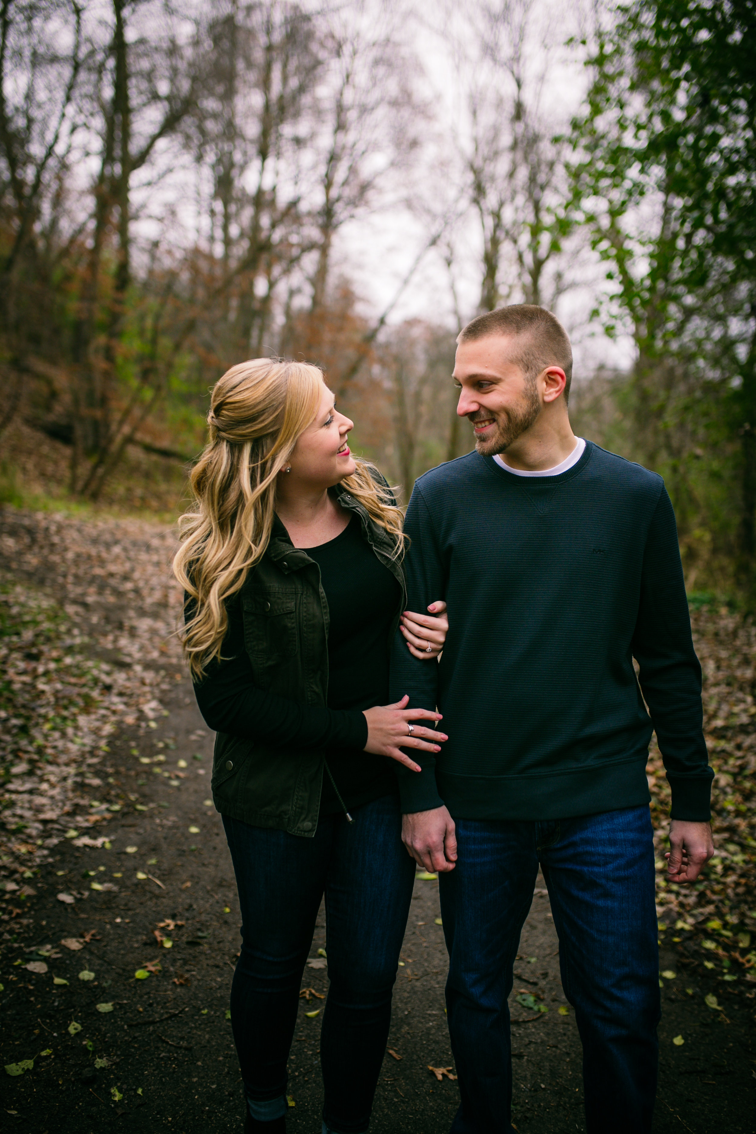 engaged couple walking towards Kinnickinic River