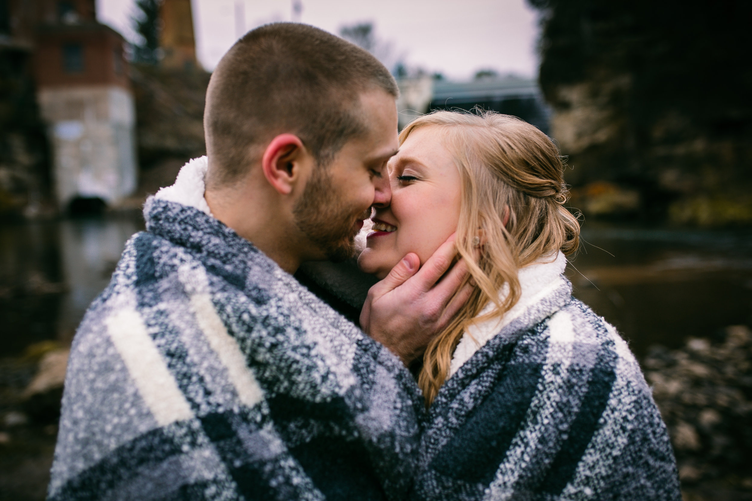 couple kissing at Kinnickinic River dam in River Falls Wi