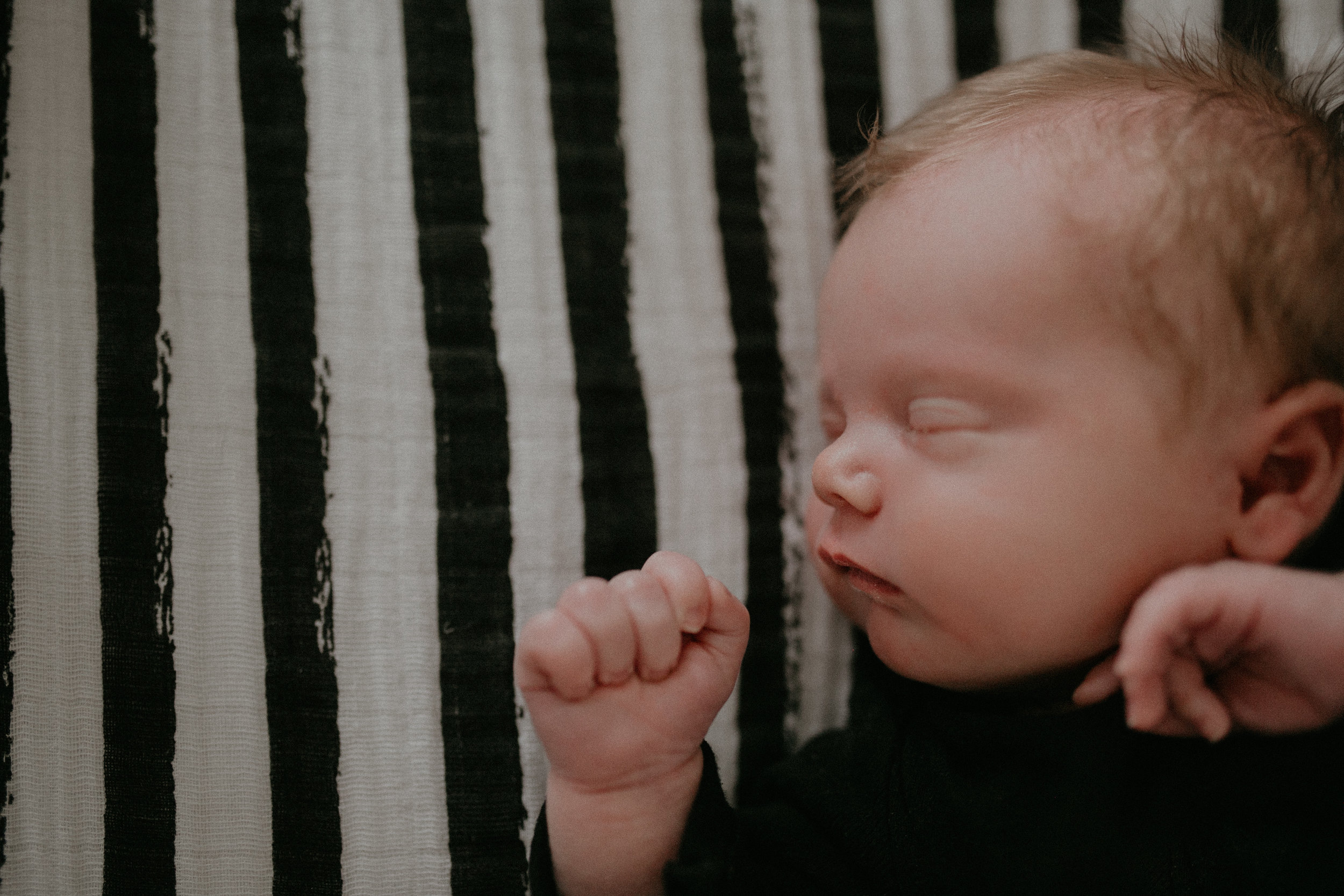 black and white striped sheet newborn baby boy sleeping