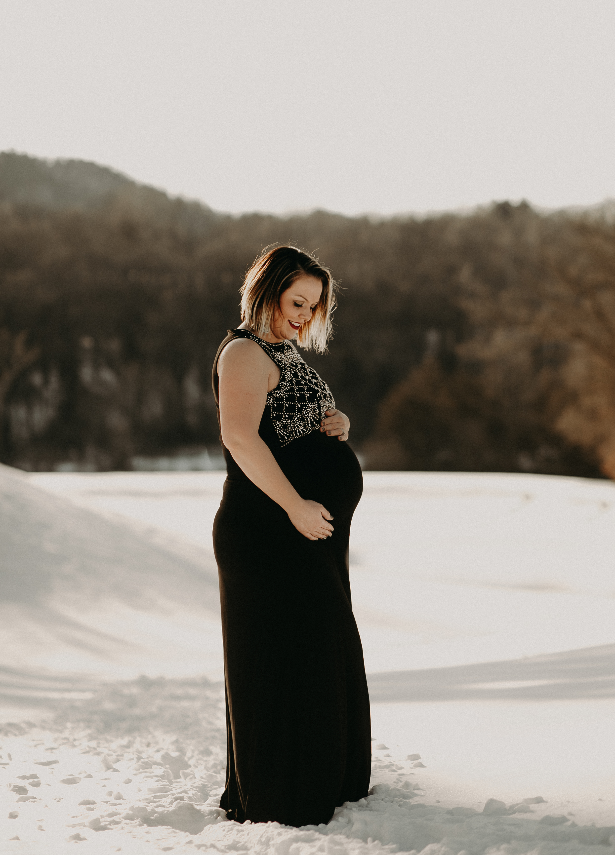 pregnant woman at sunset in snow in river falls wi
