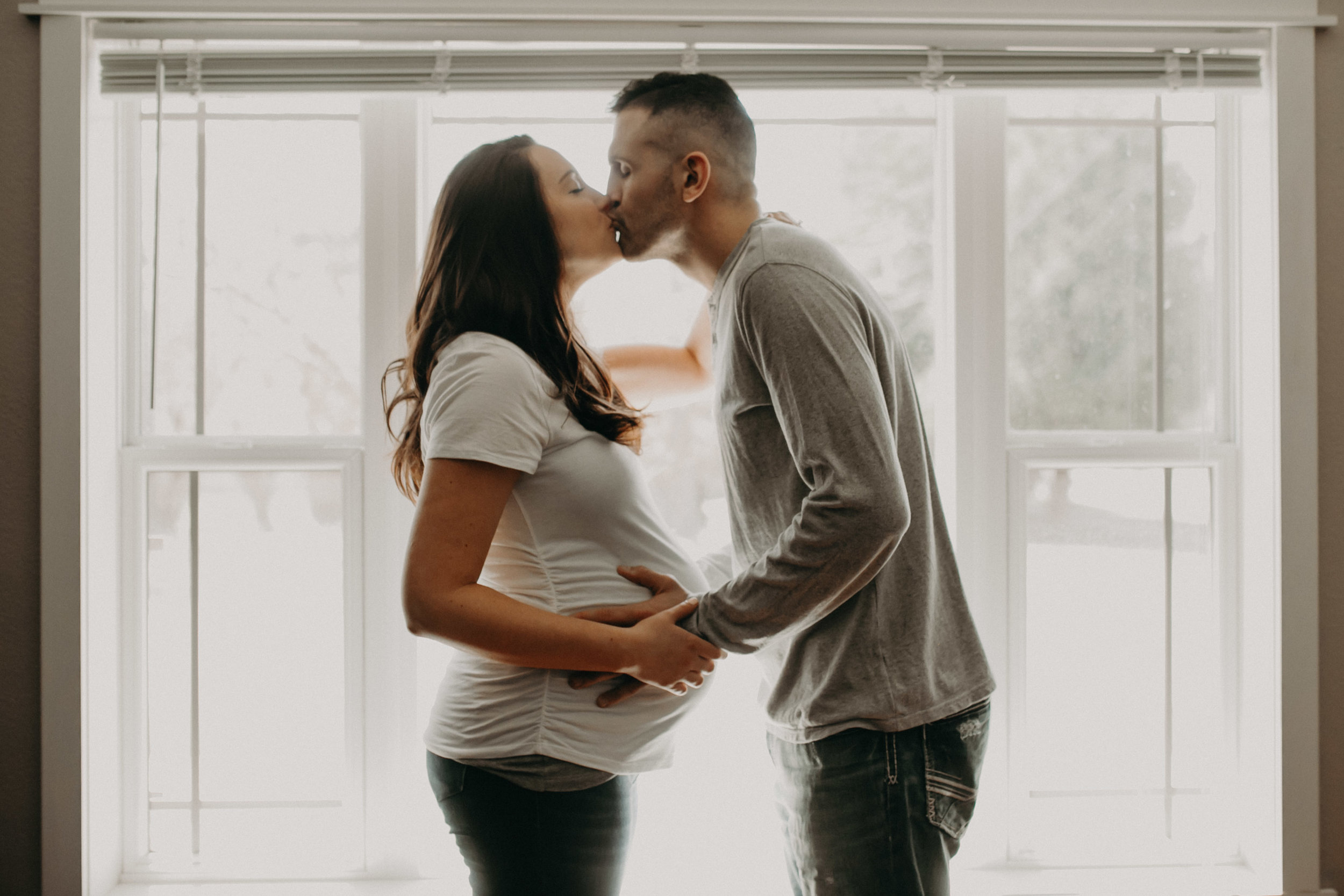 man and woman kissing pregnant maternity photos natural light