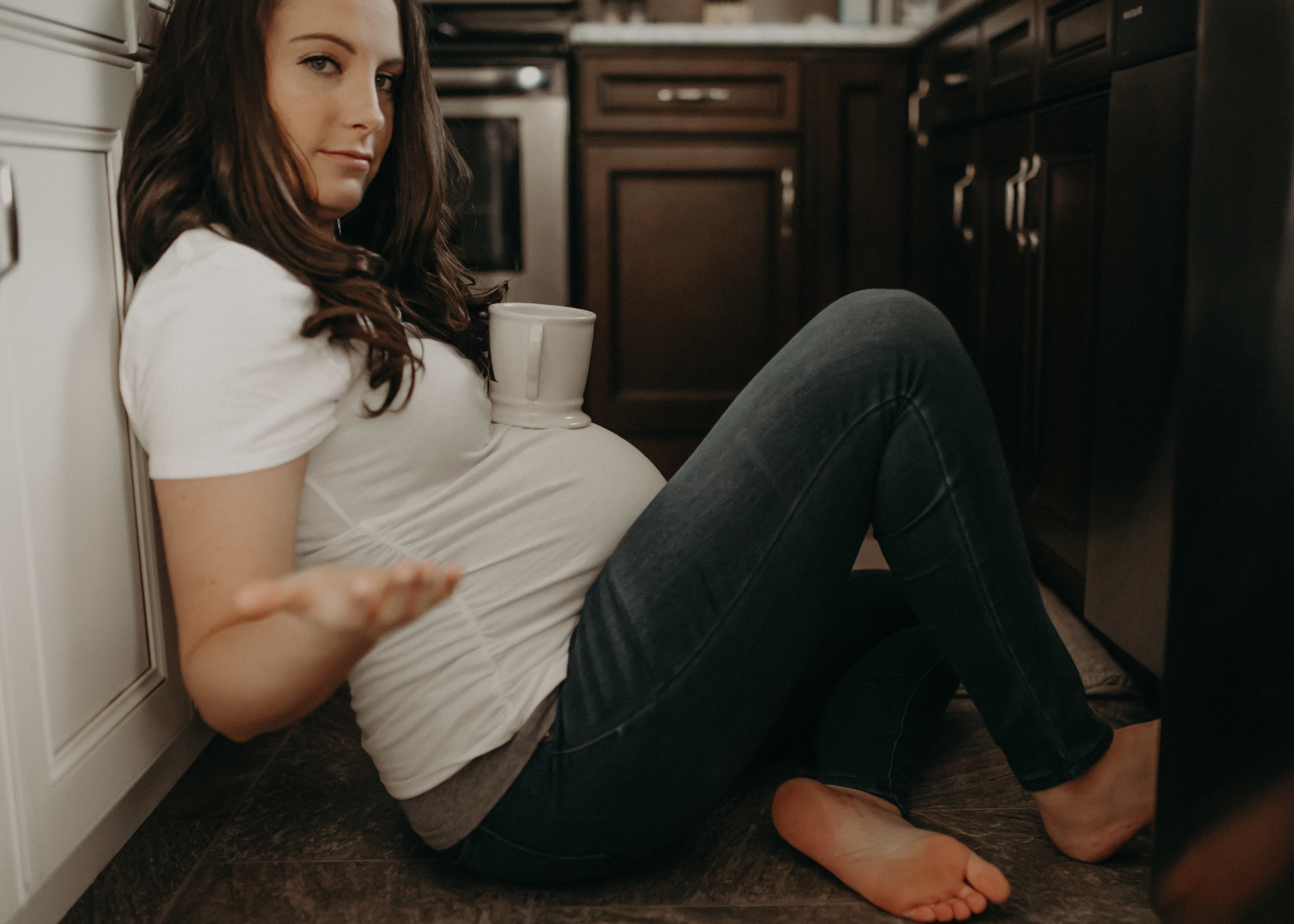 woman balancing coffee cup on pregnant belly lifestyle maternity shoot