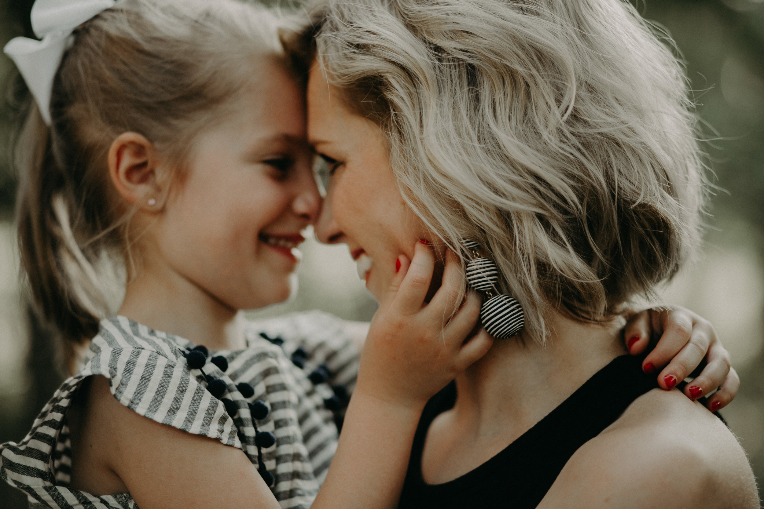 woman and her daughter smiling and giggling at sunset