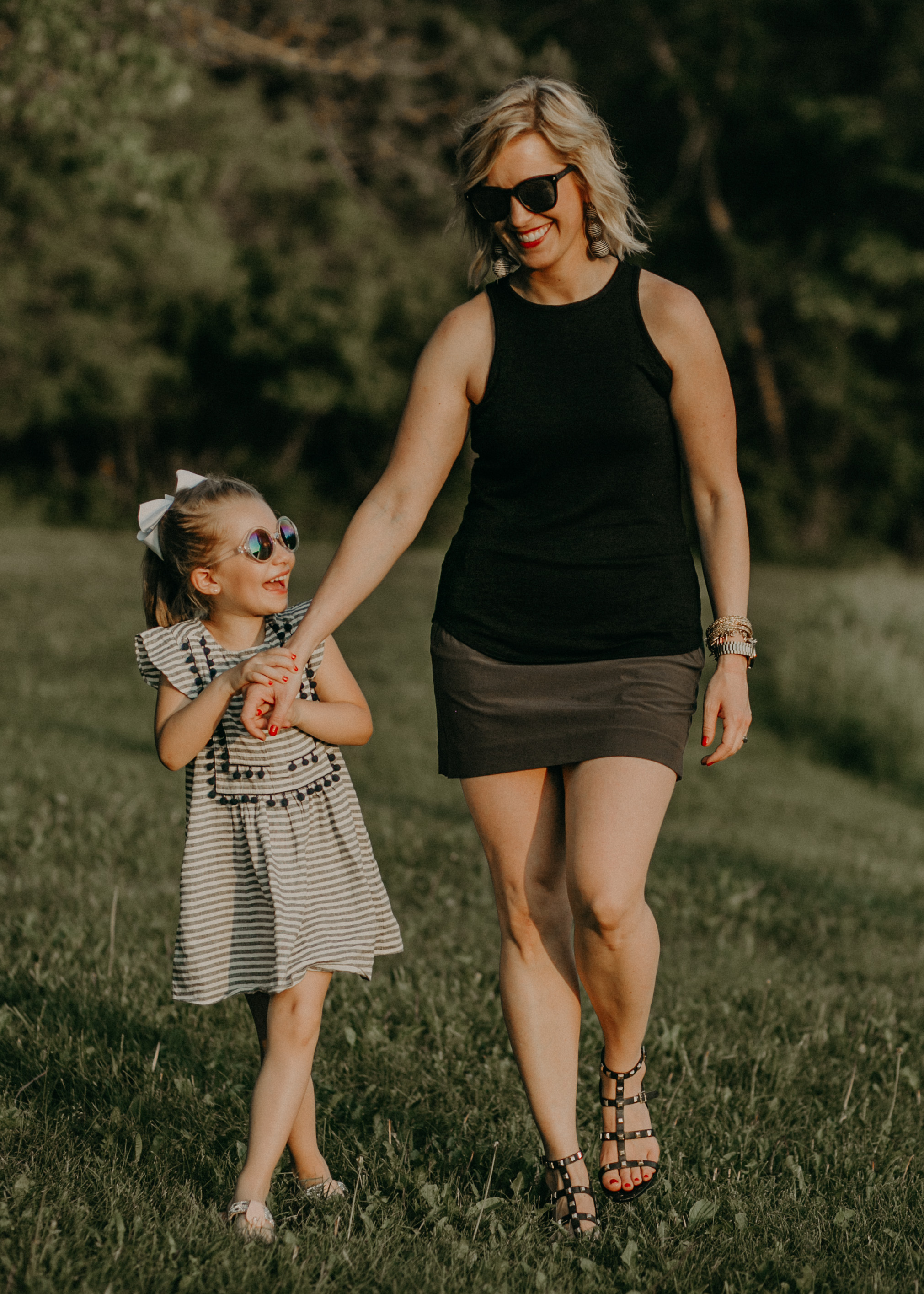  mommy and daughter from River Falls WI walking at sunset and laughing holding hands 