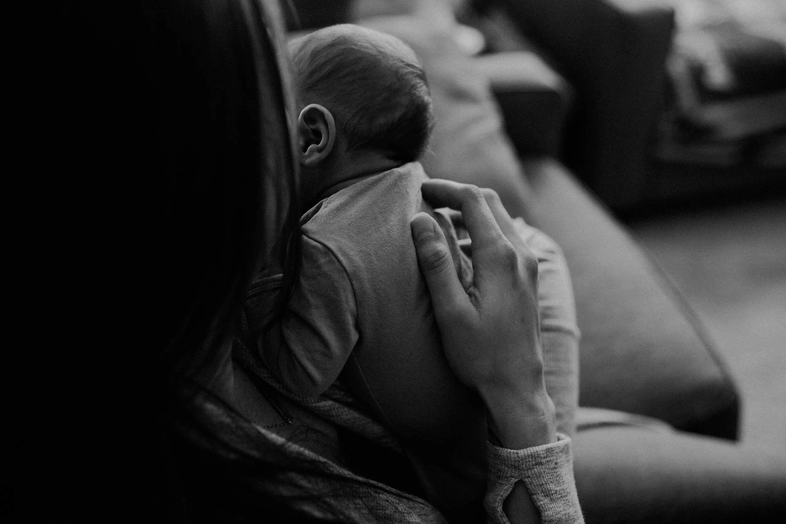 lifestyle image in black and white of mom holding newborn baby boy