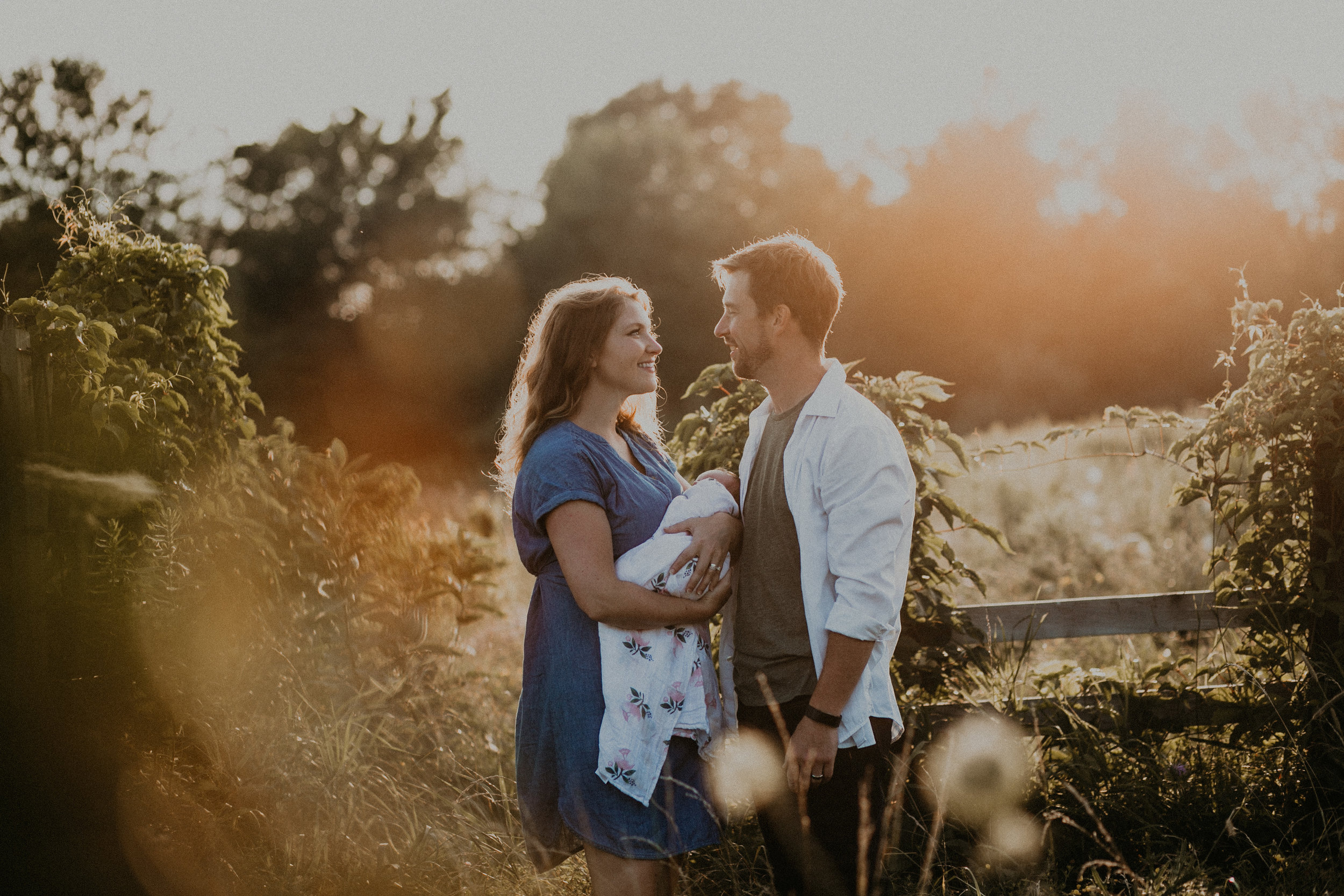 Lens flare on portrait of family of 3 during golden hour in Wisconsin