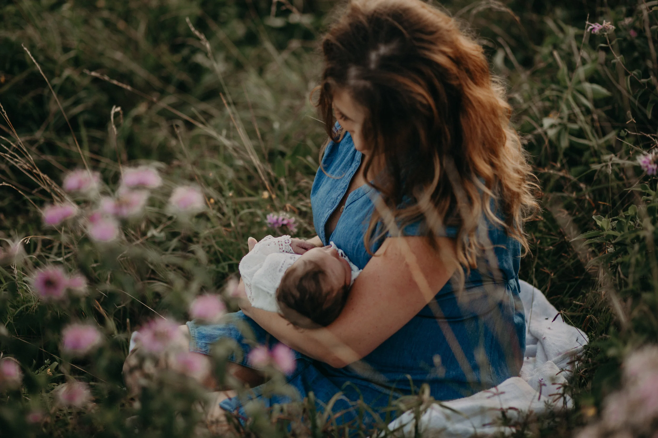 Newborn baby girl and mommy from River Falls WI in field of flowers