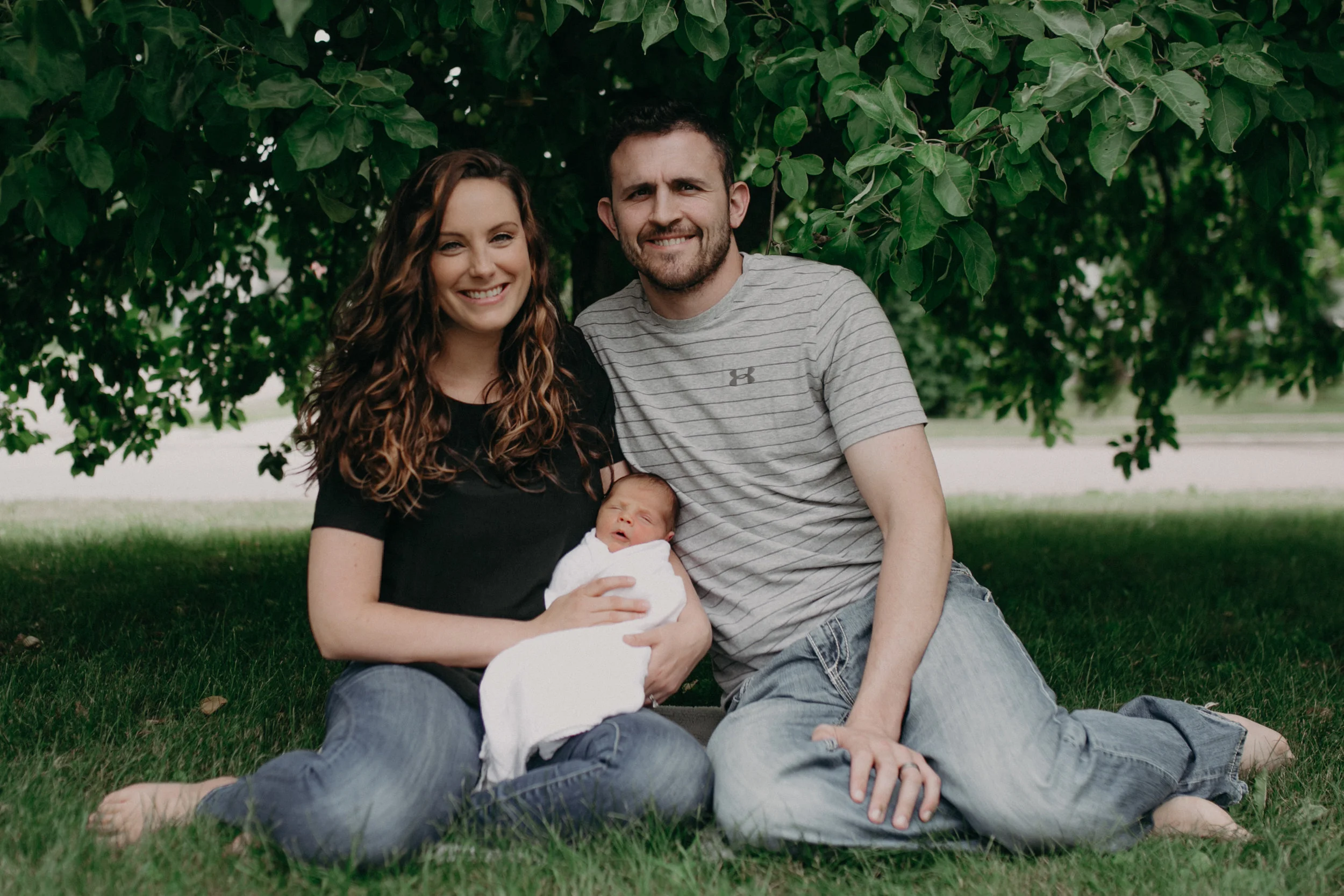 Marshfield WI family underneath tree taking pictures with newborn baby