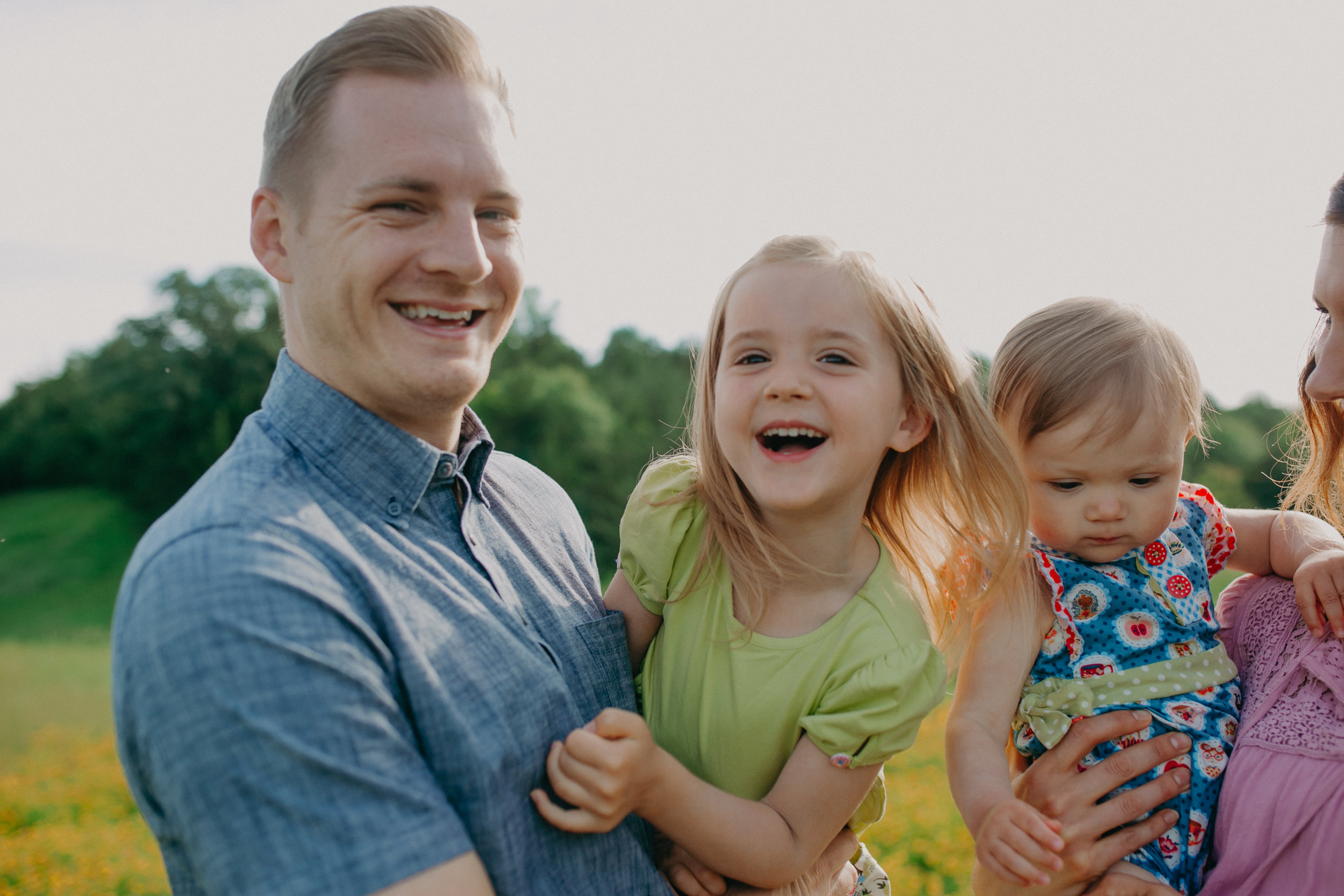 daddy and daughter tickling and laughing during field photo session in River Falls WI