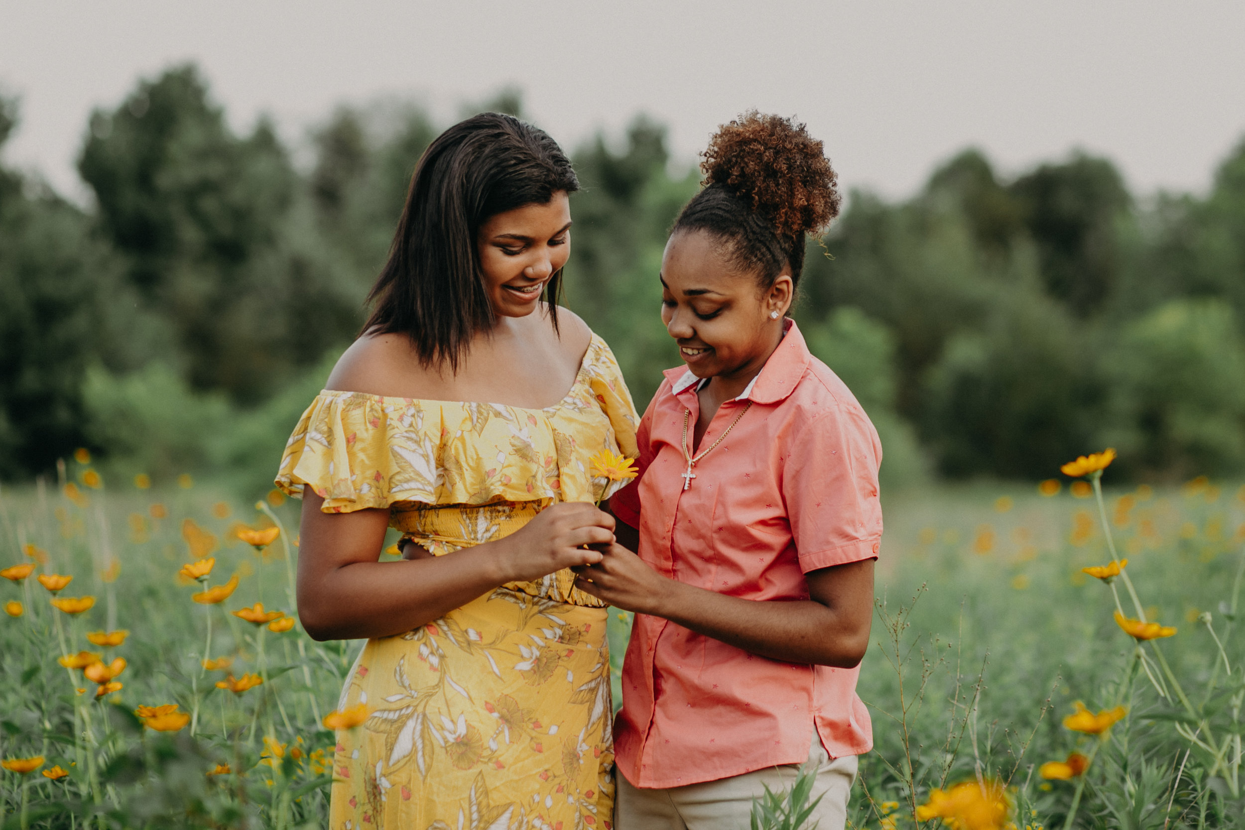  same sex couple of color in a flower field in Hudson WI for a senior session for Andrea Wagner Photography 