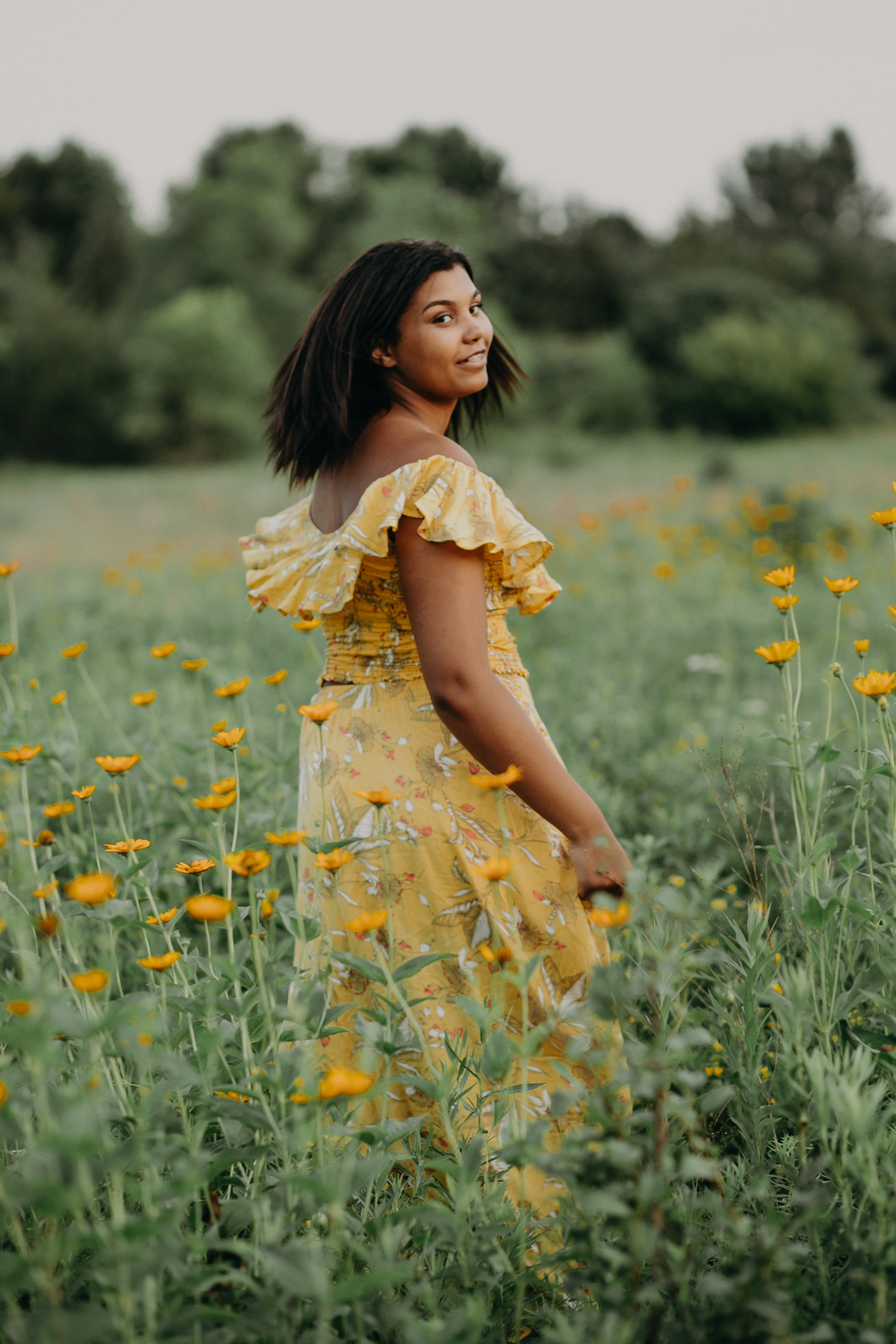  black high school senior from Bloomington MN twirling in a yellow dress in a flower field 
