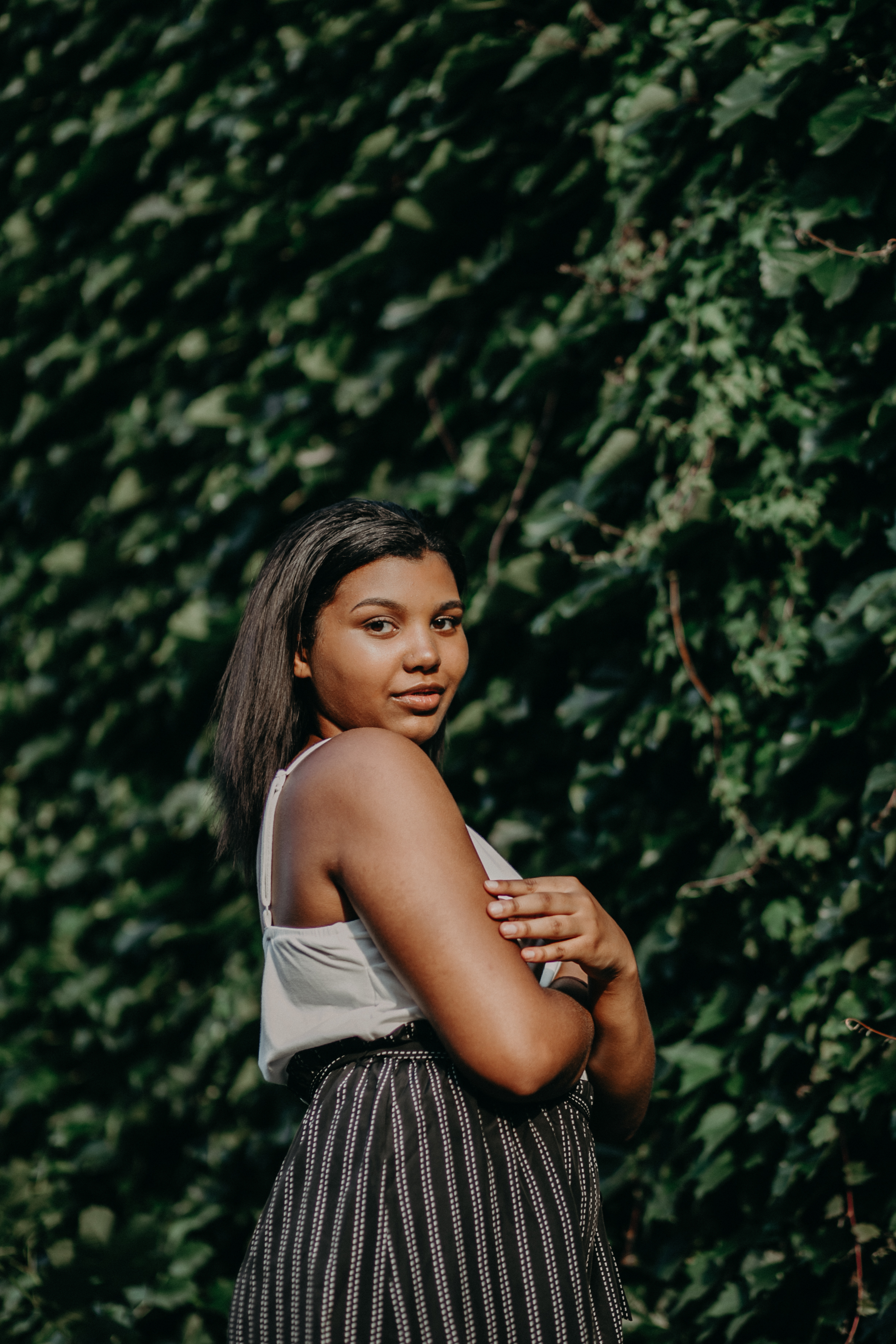black high school senior posing in front of ivy in Hudson WI during her senior photo session