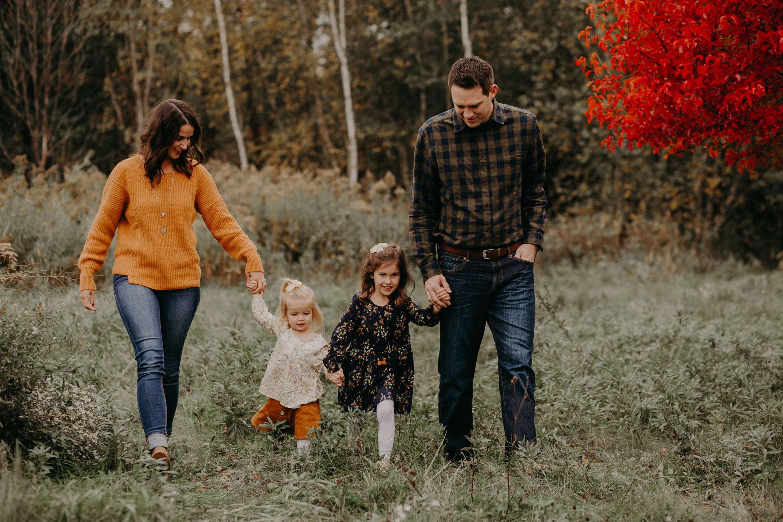 family walking and holding hands during a fall family photo session in River Falls WI