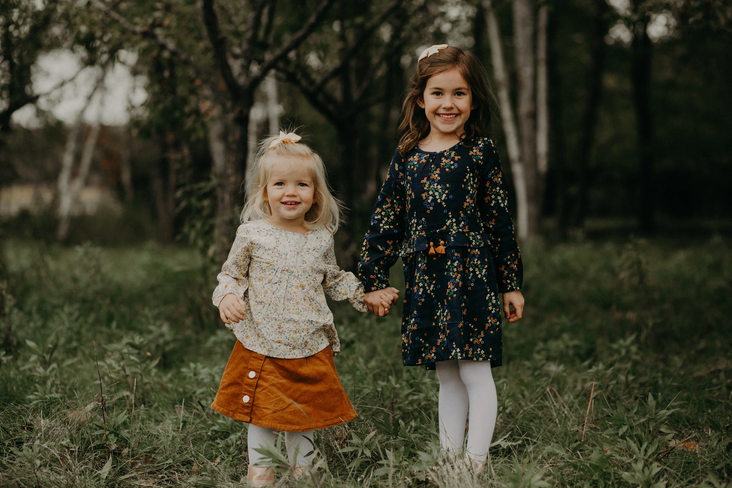 sisters from Woodbury MN hold hands during lifestyle family photo session
