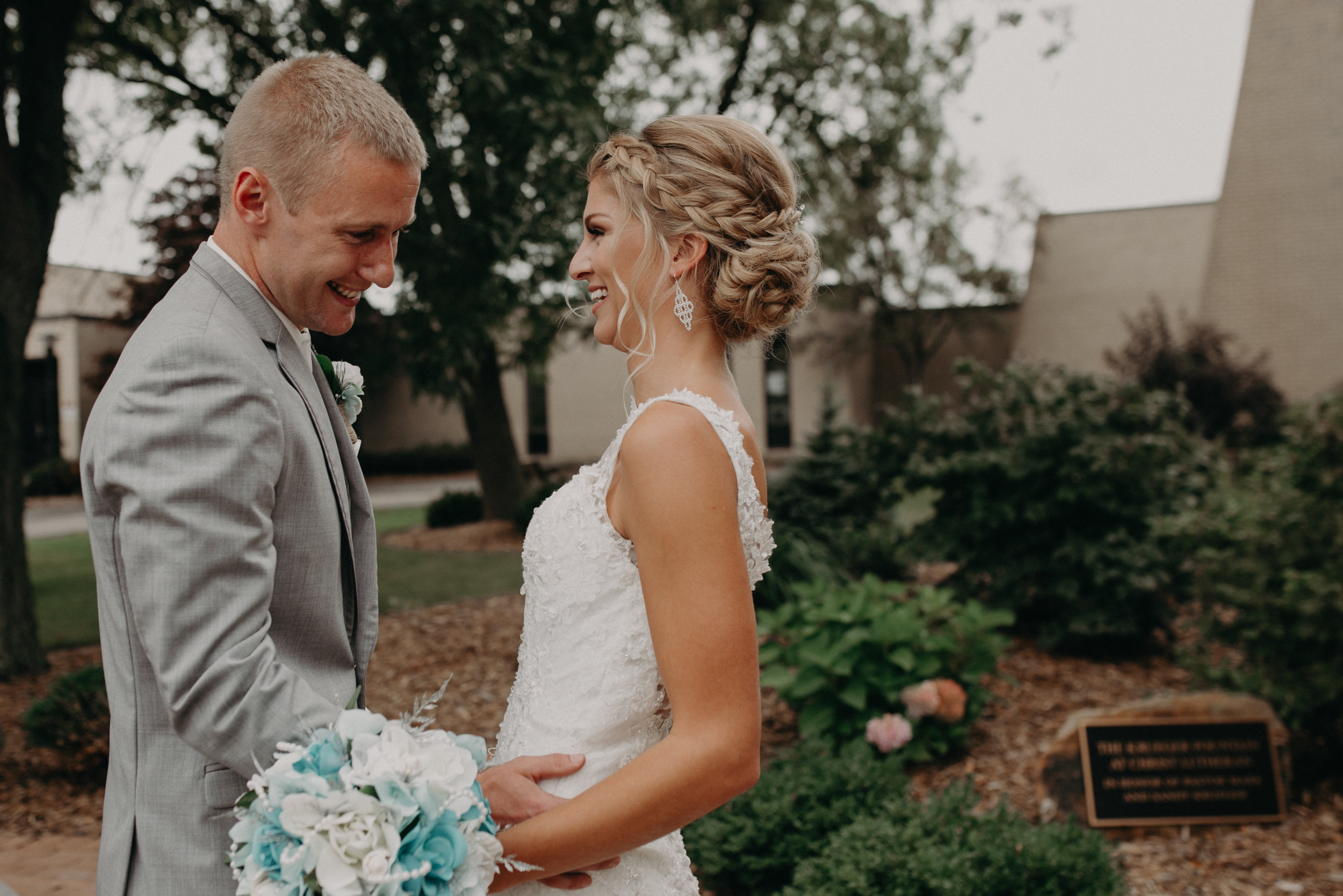 groom blushes as he sees his bride for the first time before his wedding at Christ Lutheran Church in Marshfield WI