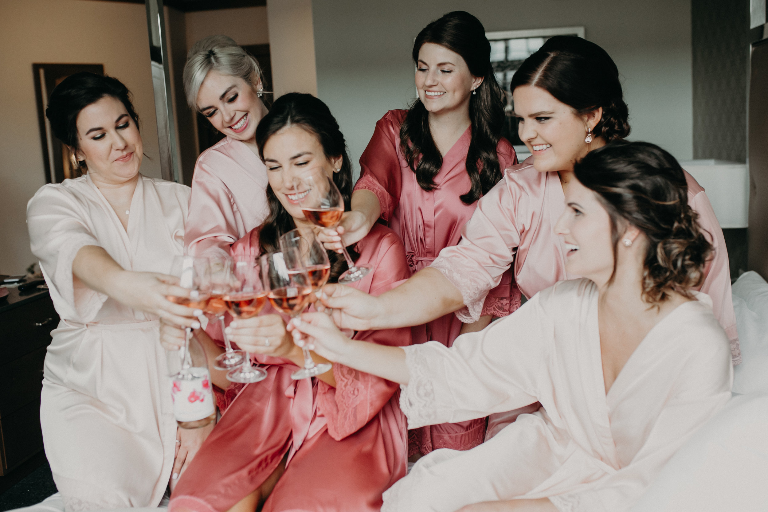  pink bride tribe getting ready for a lakeside wedding and drinking champagne in Wayzata MN at Hotel Landing 