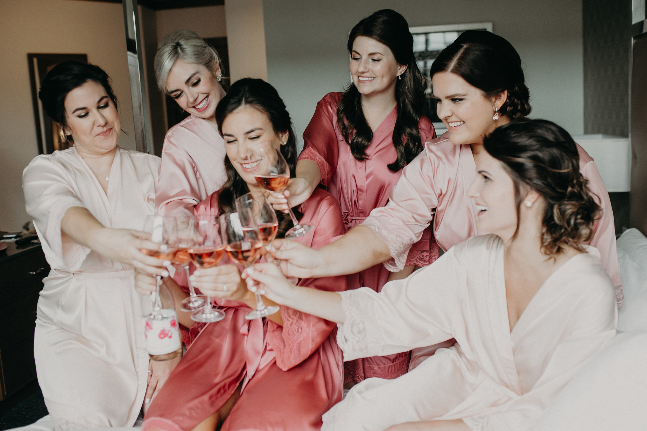 pink bride tribe getting ready for a lakeside wedding and drinking champagne in Wayzata MN at Hotel Landing