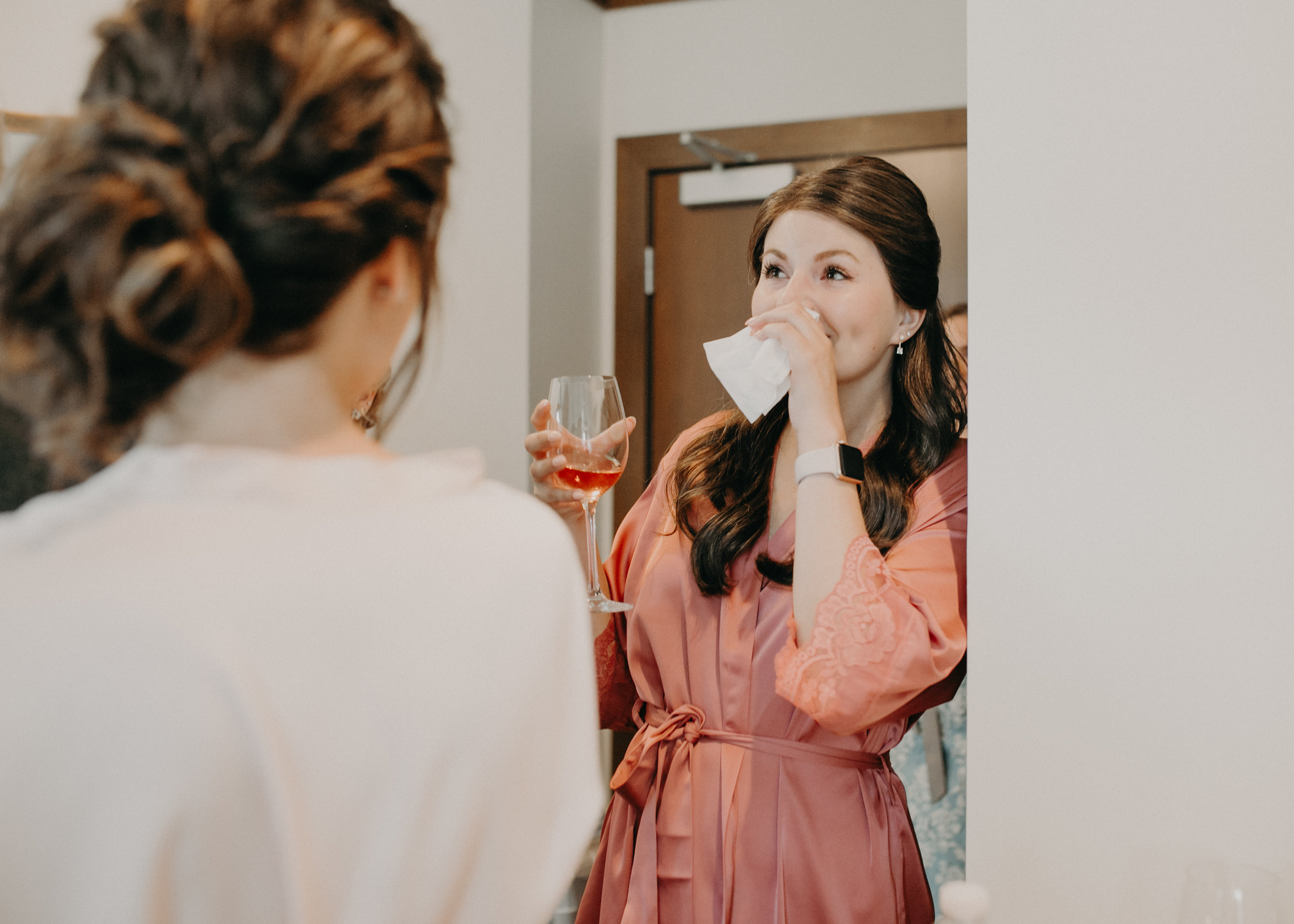 bridesmaid cries as bride gets into her wedding dress at Hotel Landing in Wayzata MN