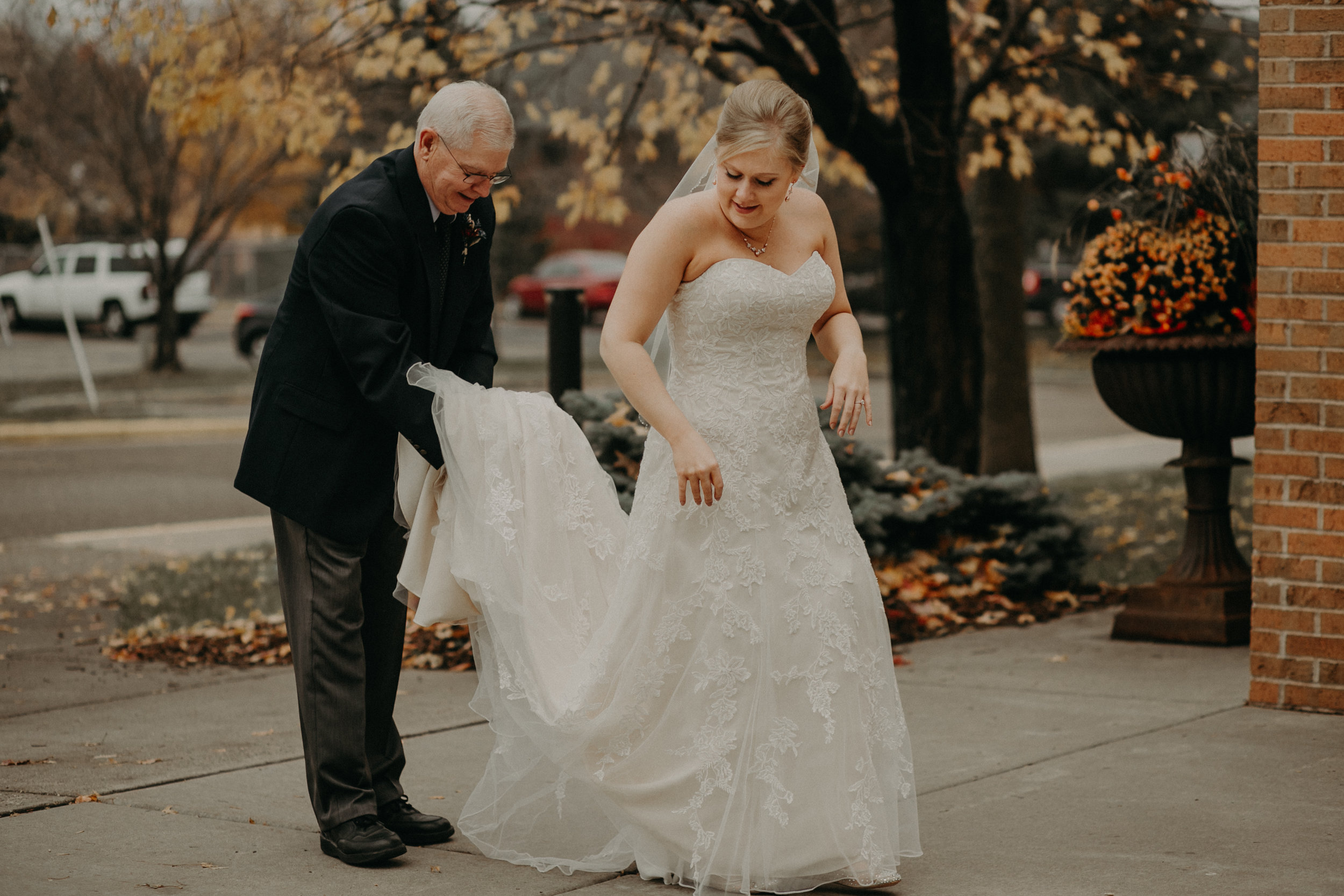 Grandfather holds bride’s dress during first look at her wedding in River Falls