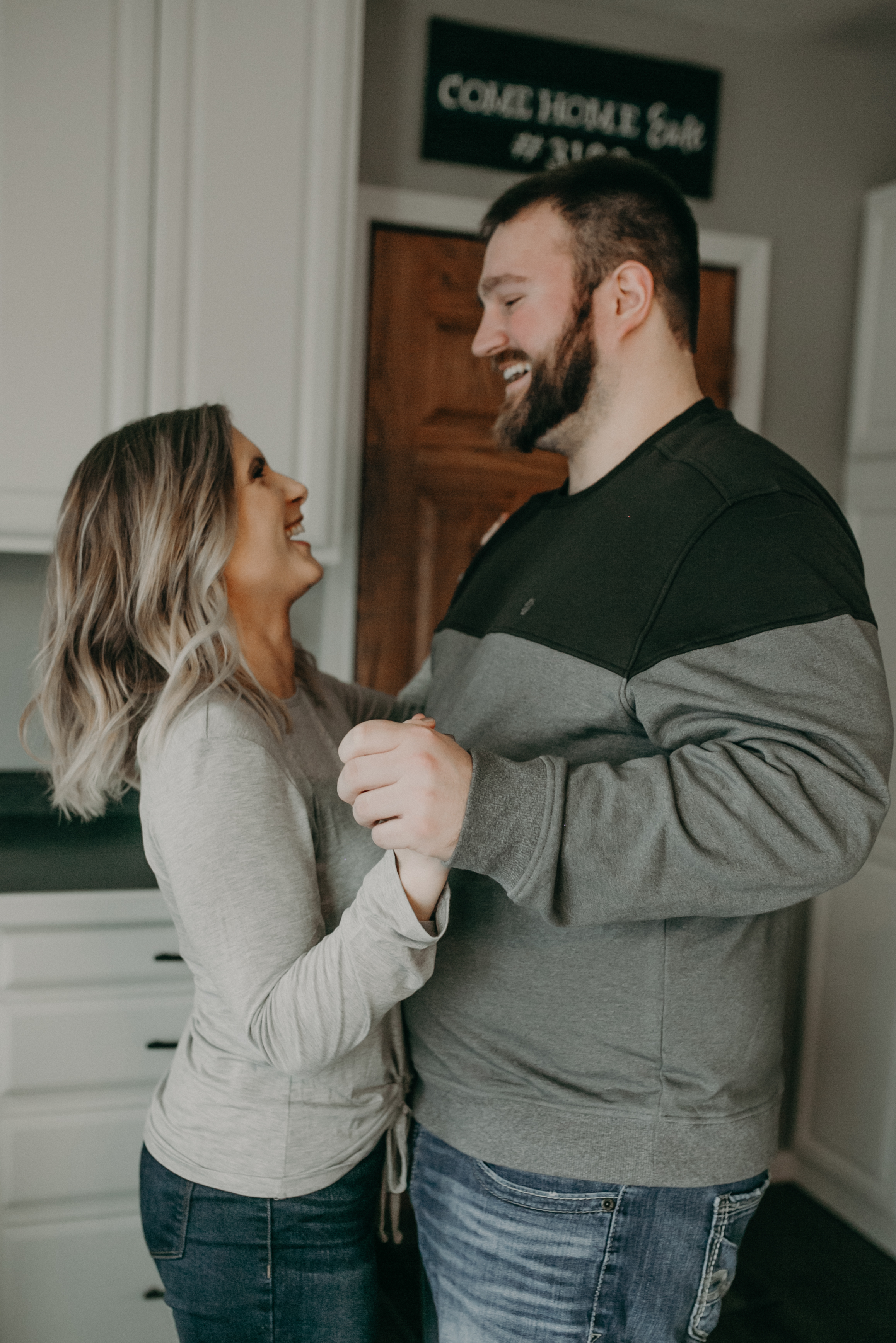  a couple dances in their kitchen during their in home engagement session in Wisconsin 
