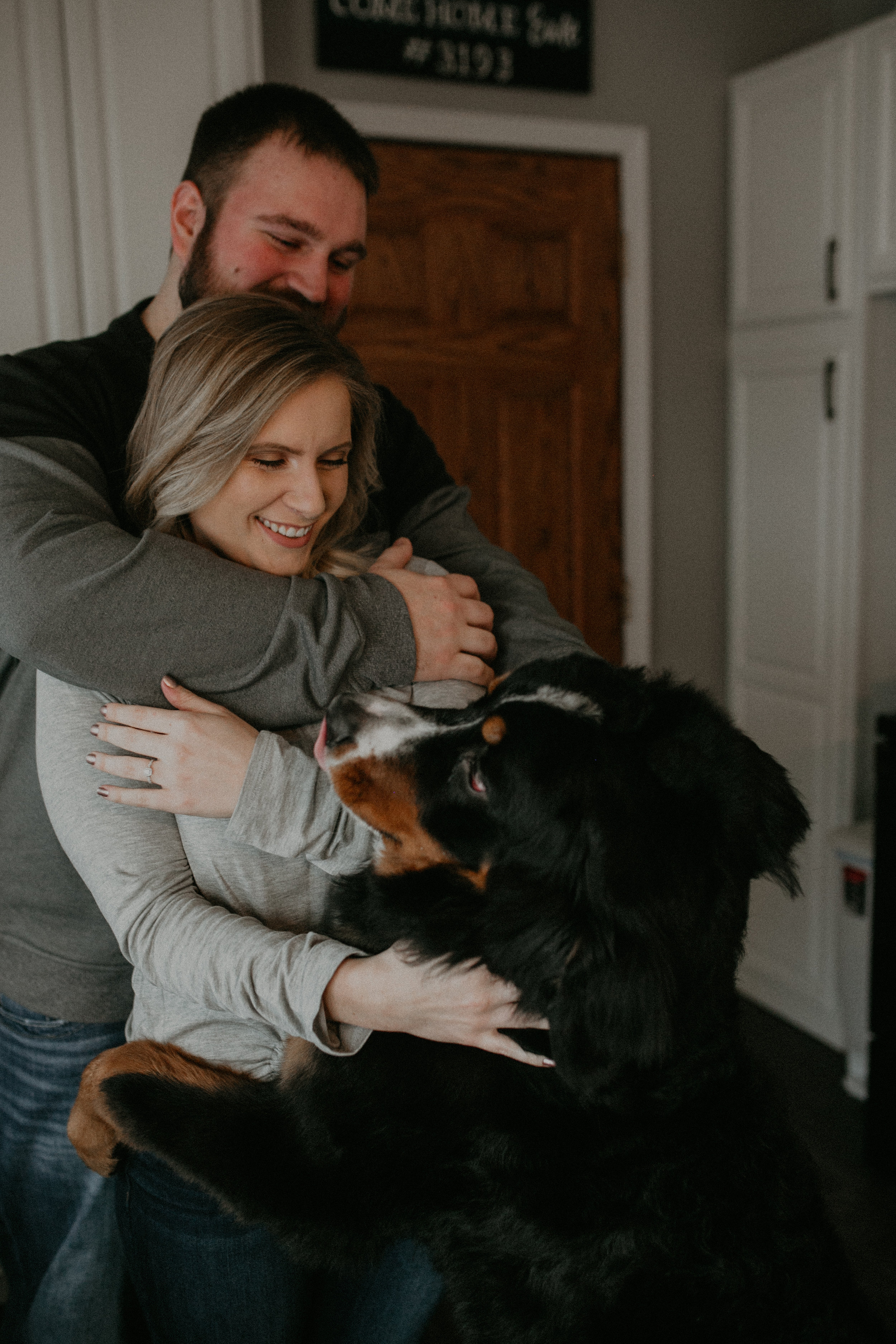  puppy joins in on engagement session in kitchen with couple in Wisconsin 