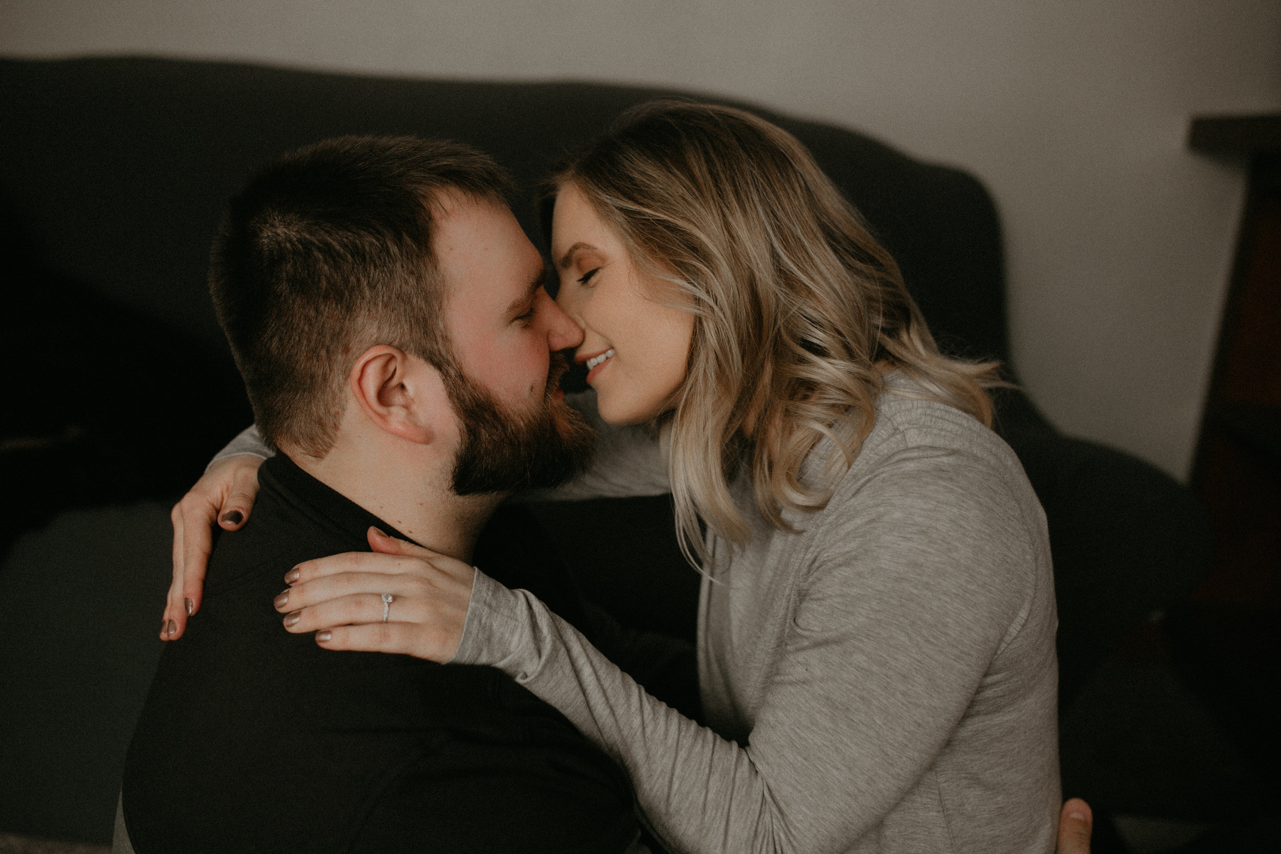  Athens WI couple kisses in their living room during their engagement session 