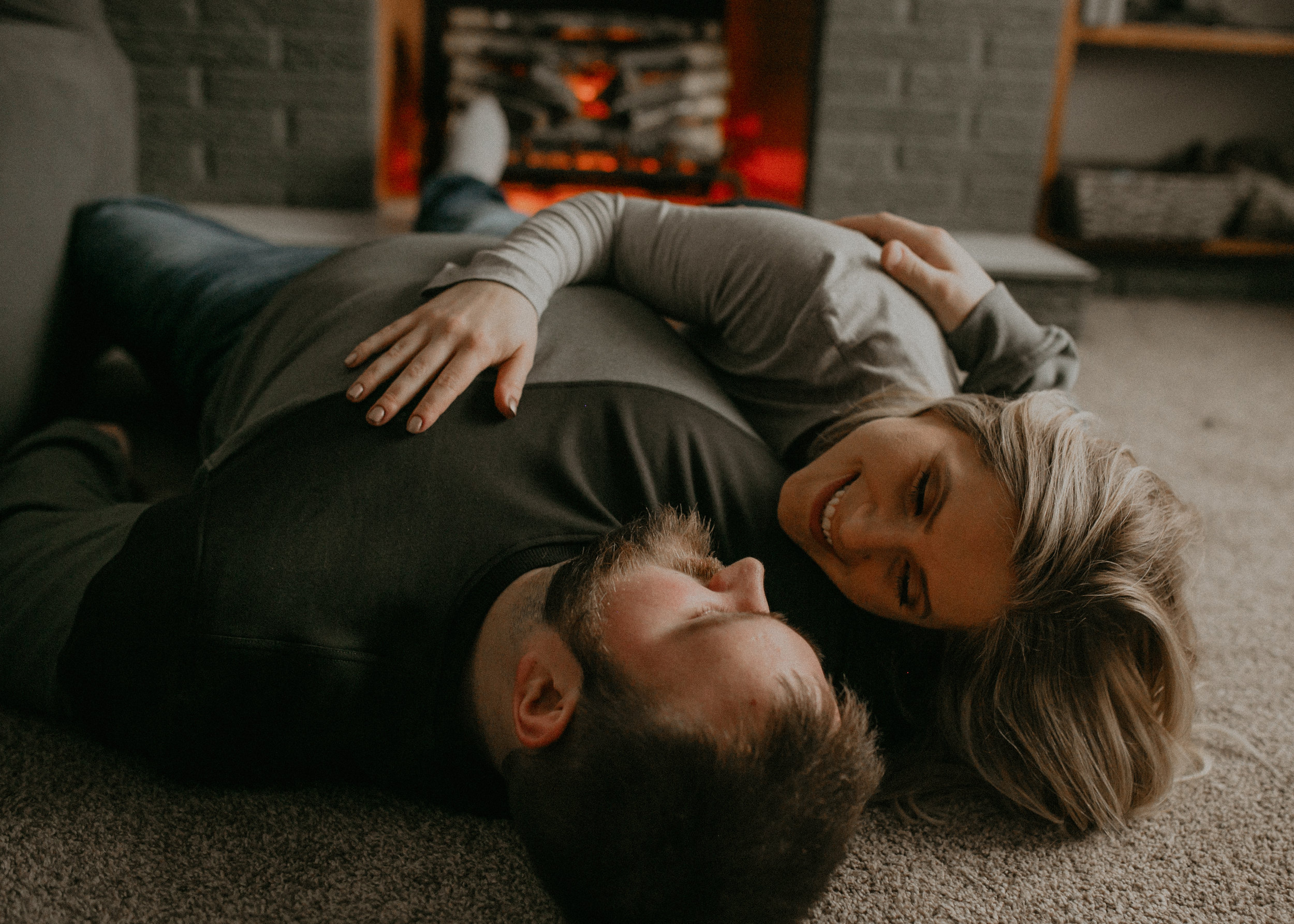 snuggles in front of the fireplace during lifestyle engagement session with Wisconsin wedding photographer Andrea Wagner 