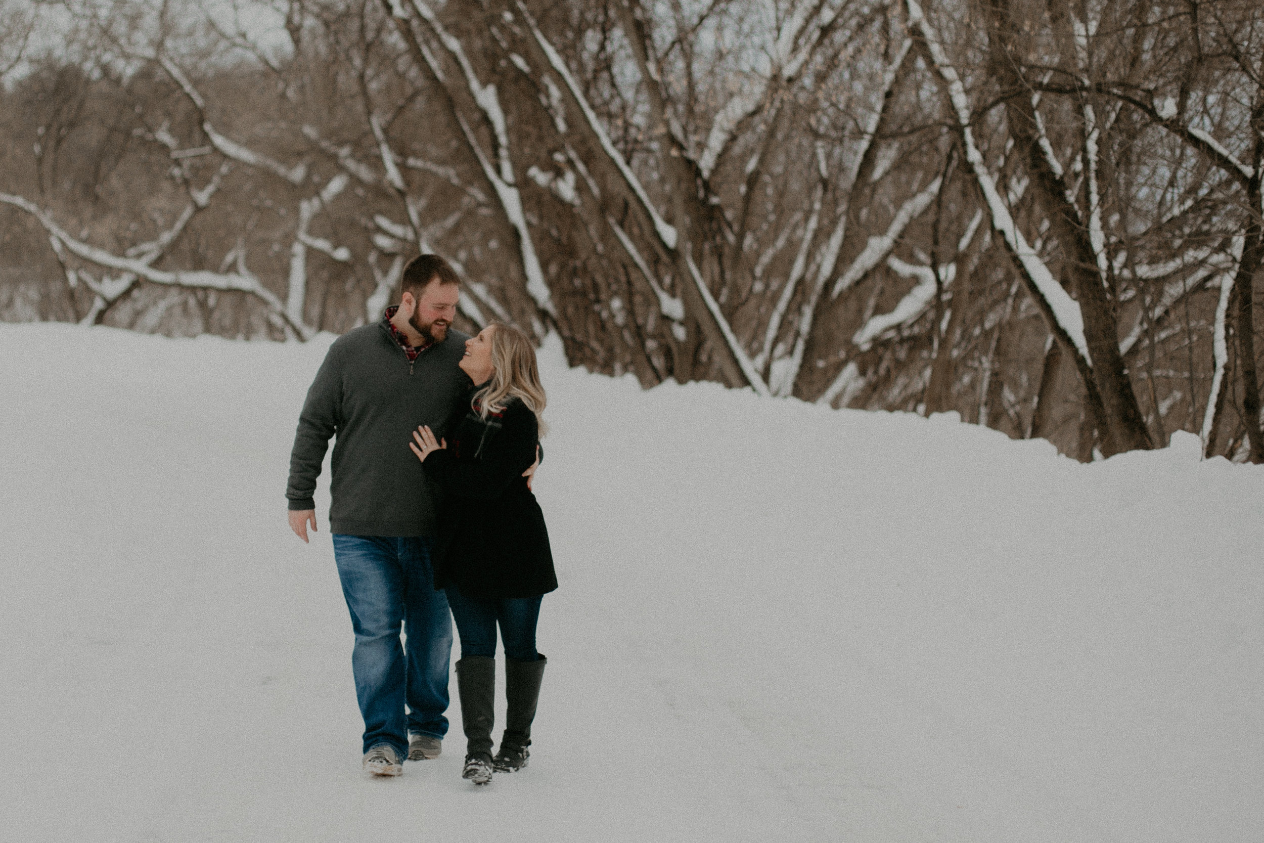  Wausau WI police officer snuggles in the winter snow with his fiancé during their engagement session 