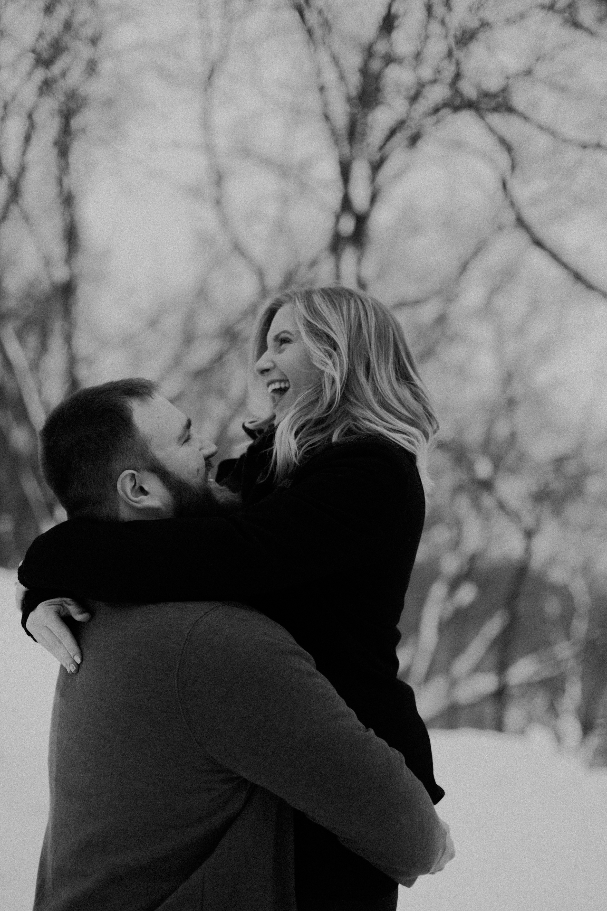  happy engaged couple flirts in the snow during their lifestyle engagement session in Athens WI 