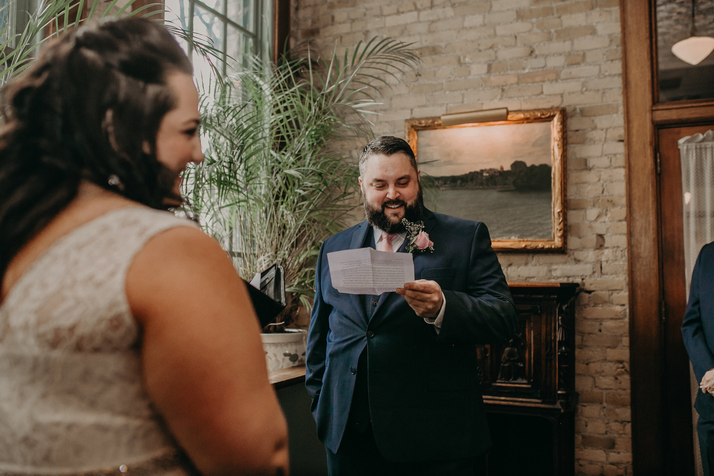 A Twin Cities groom reads his vows to his wife during their intimate ceremony at W. A. Frost in St Paul MN