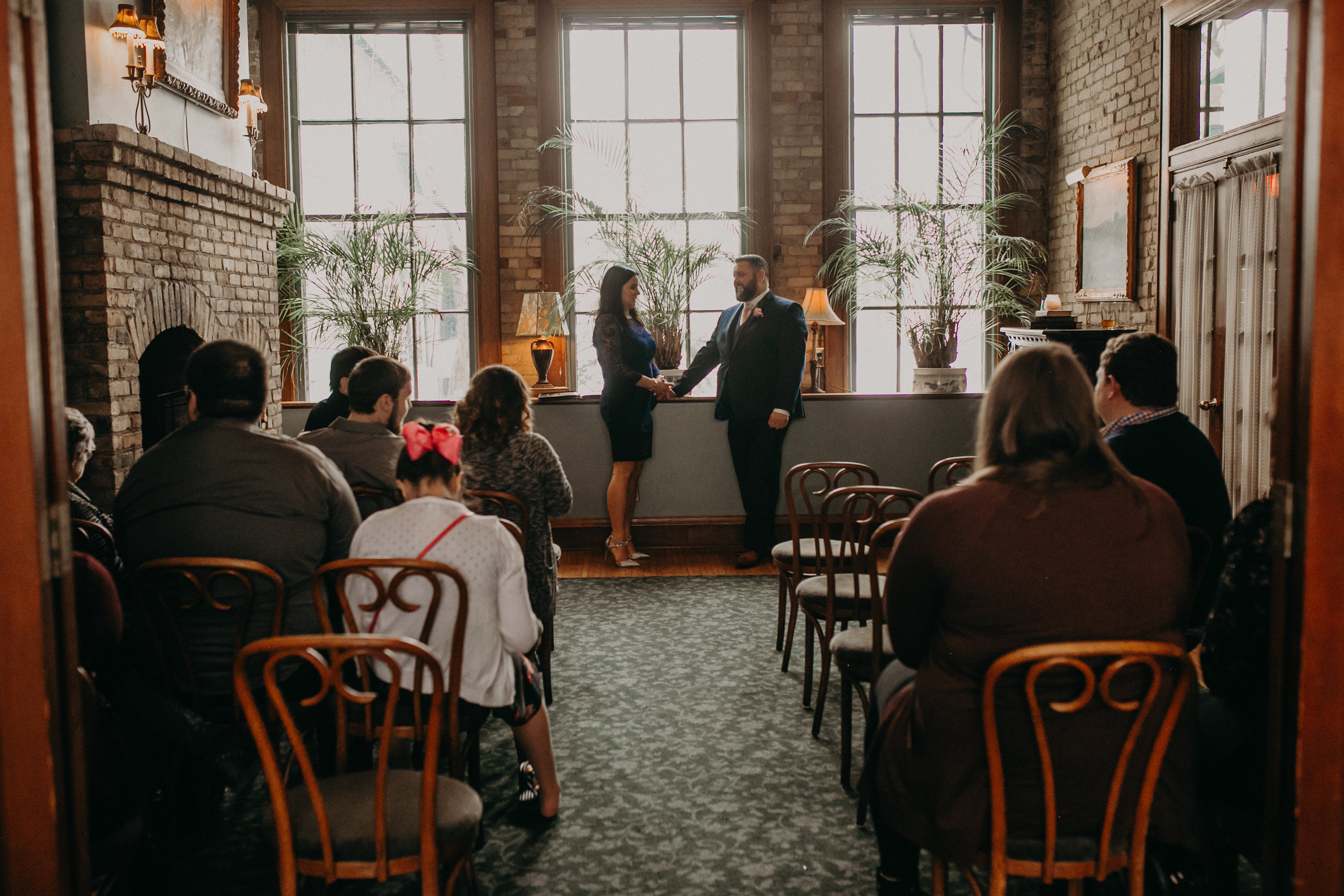 A groom holds his sister’s hand before the wedding ceremony in St Paul at W.A. Frost
